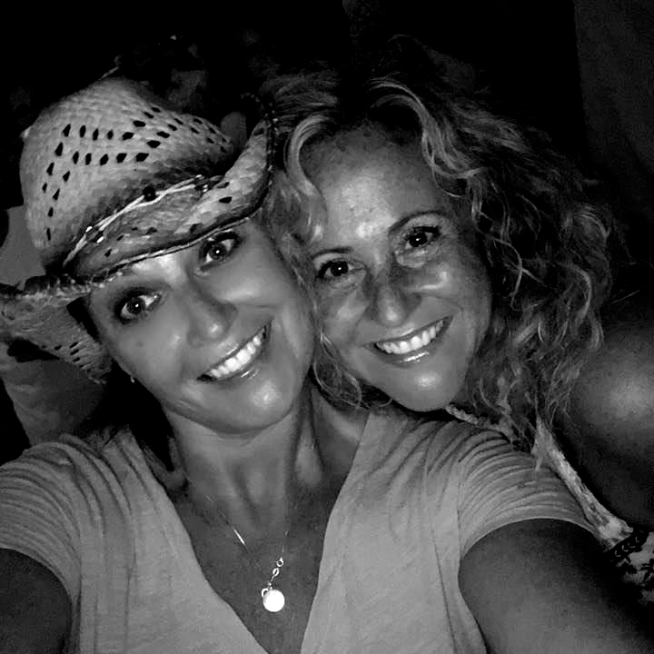 Two smiling women, one wearing a cowboy hat, taking a selfie.