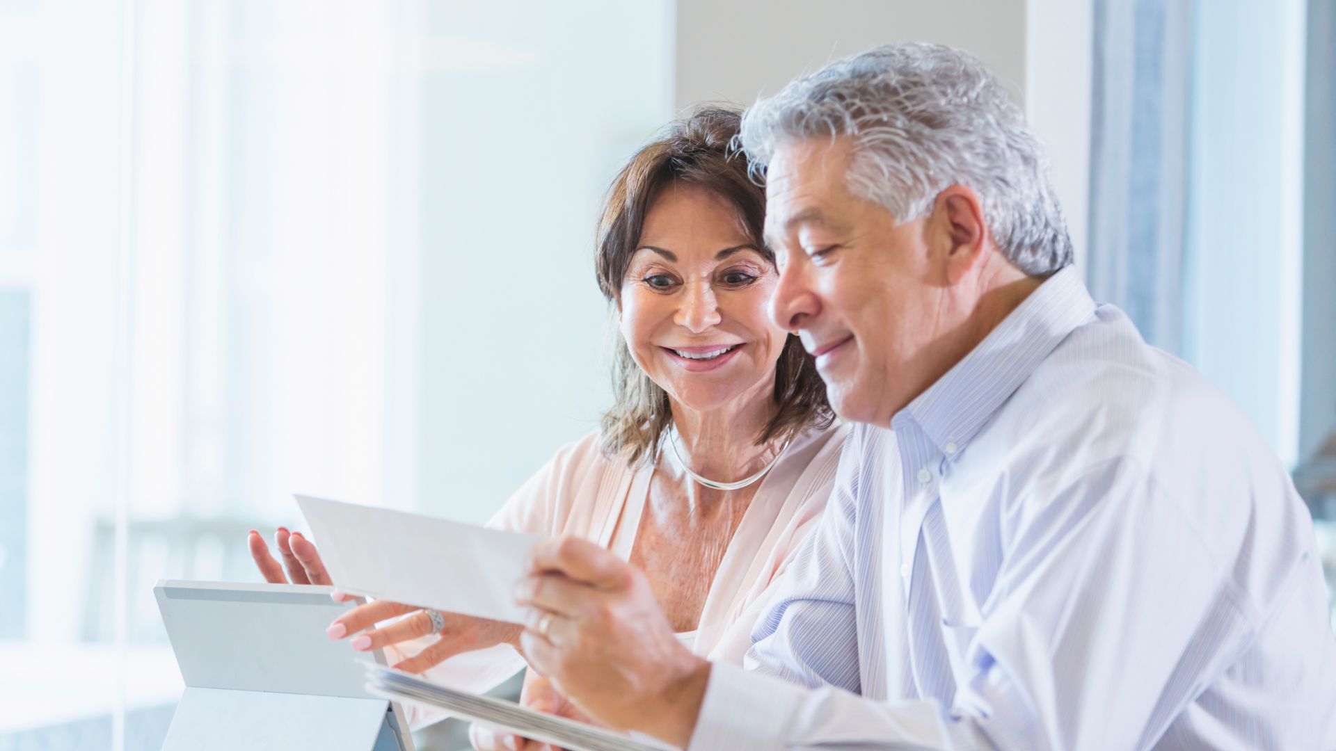 A man and a woman are looking at a tablet together.