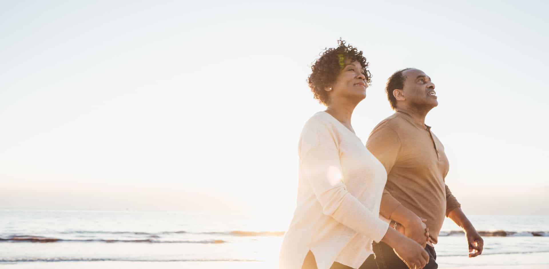 Man and a woman are walking on the beach. This treatment may provide significant symptom relief for people suffering from hip pain due to injury or degenerative problems.