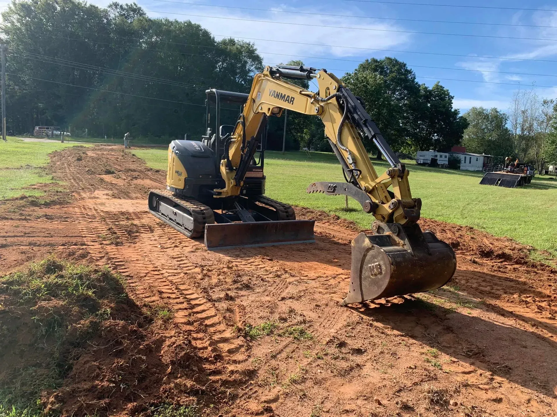 Yellow excavator digging in a dirt area, preparing ground for construction.