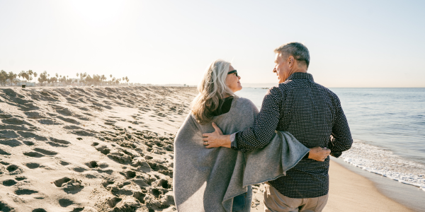 couple walking on beach talking about their funeral plans