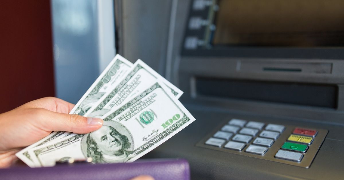 A person is taking money from an atm machine.