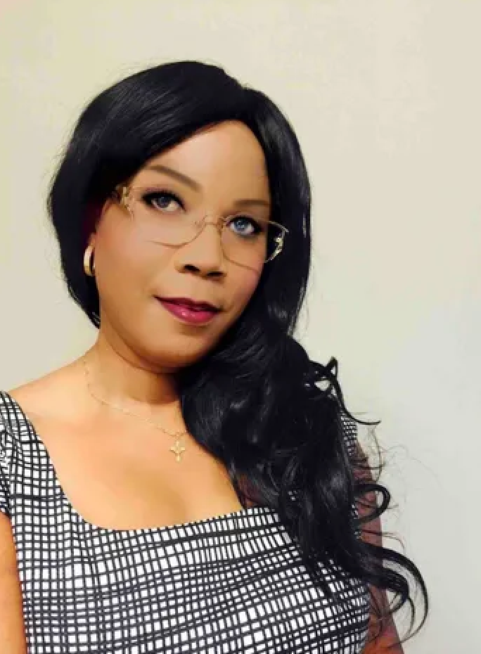 A woman with long brown hair is wearing a white jacket