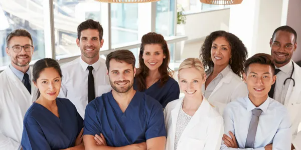 A group of doctors and nurses are posing for a picture in a hospital.