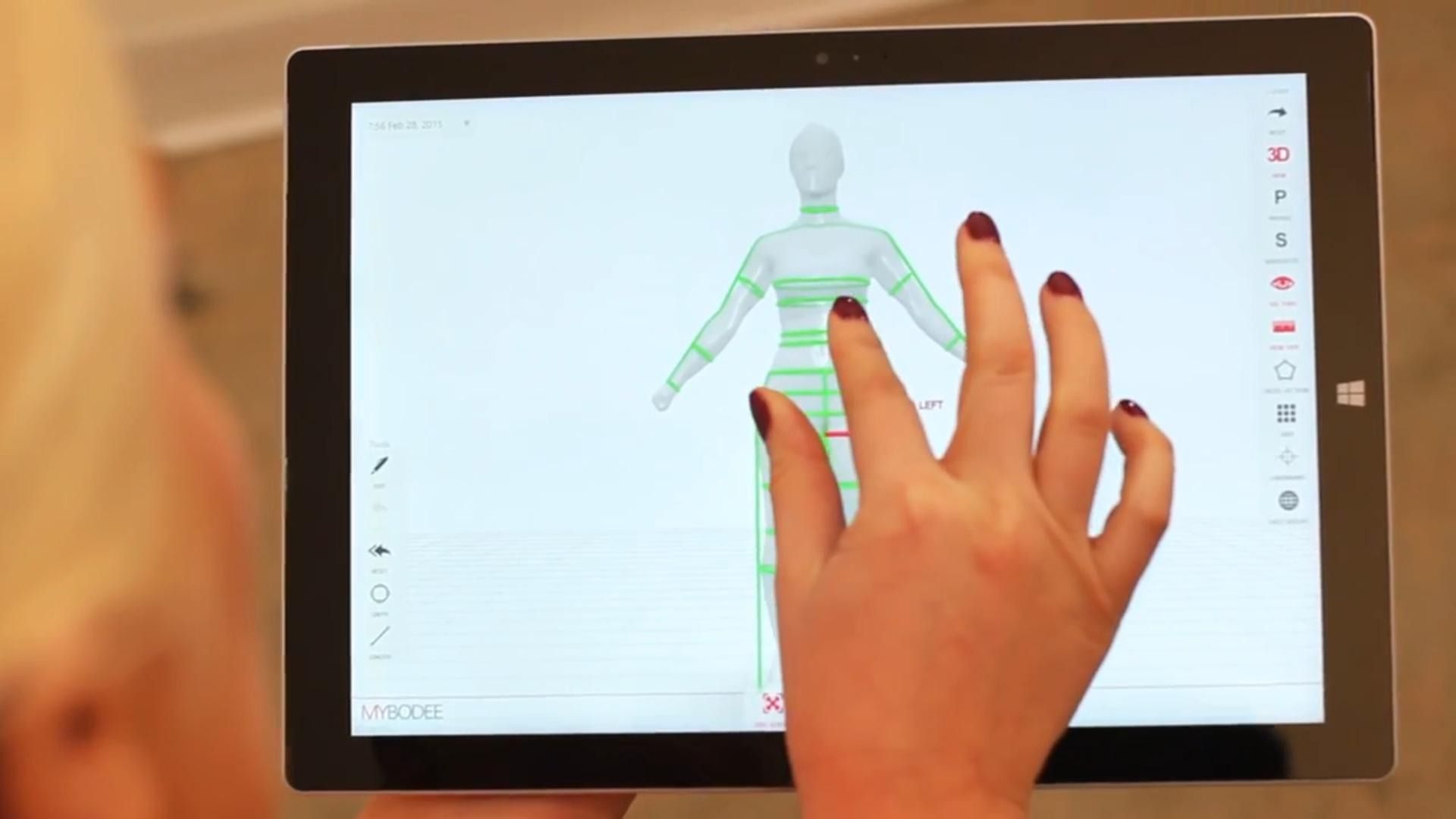 Person uses a tablet to manipulate a 3D model of a body with green and red lines.
