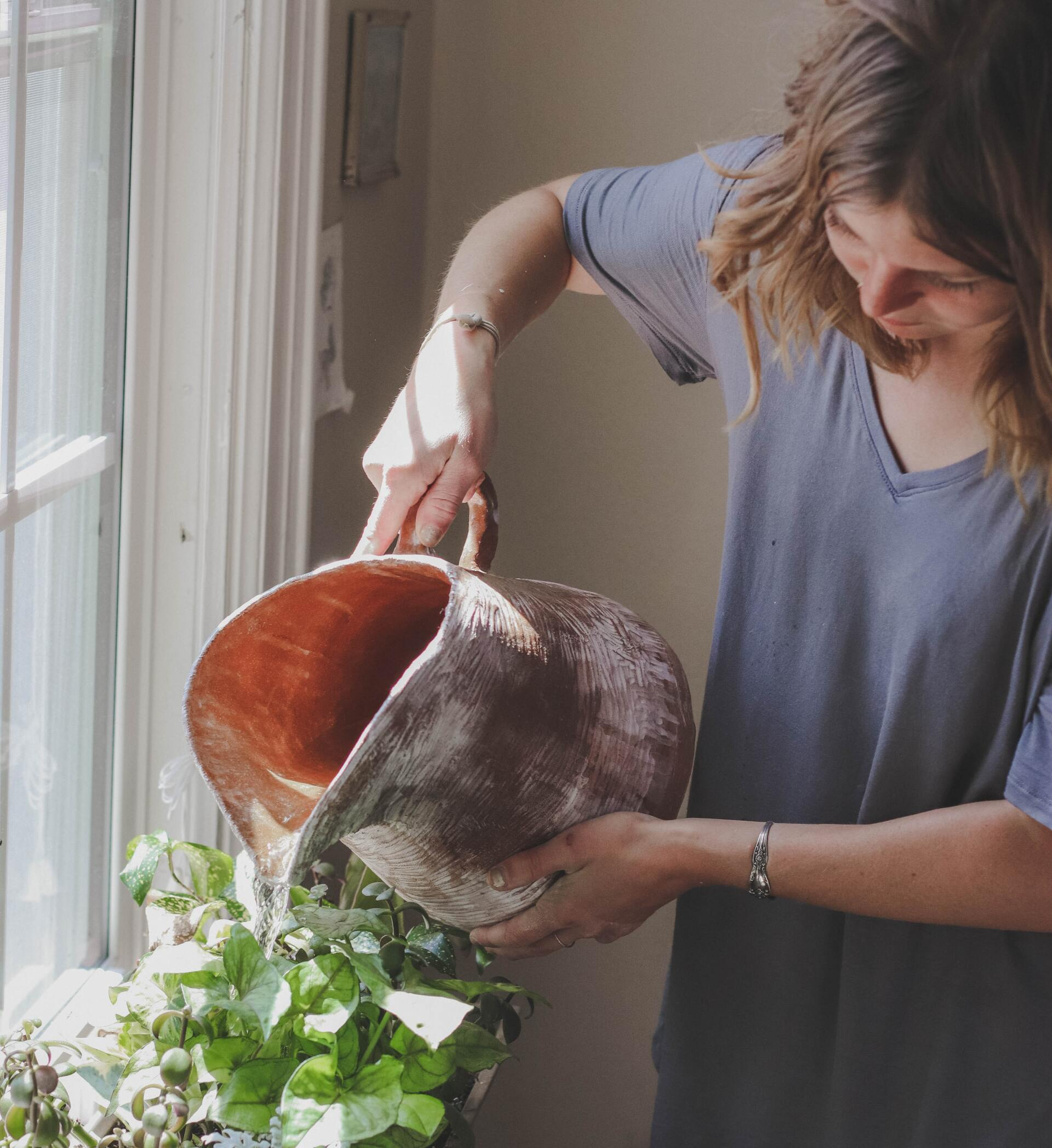 woman watering indoor plants