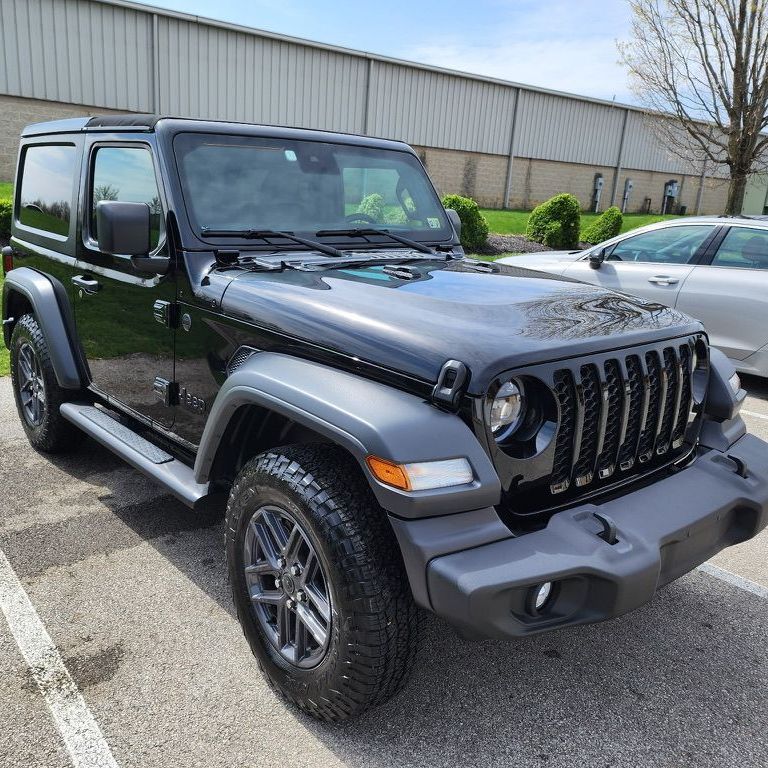A black jeep wrangler is parked in a parking lot