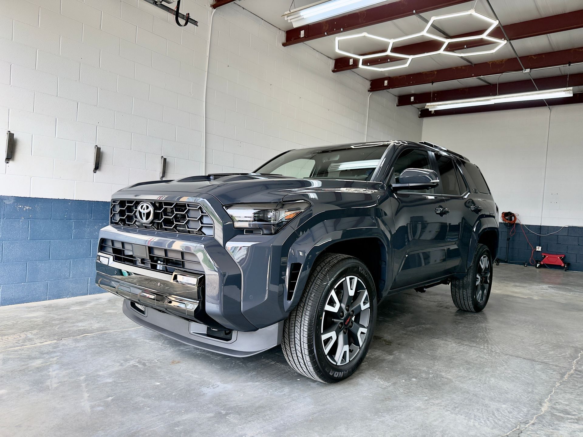 Dark gray SUV parked inside a garage, front-left view
