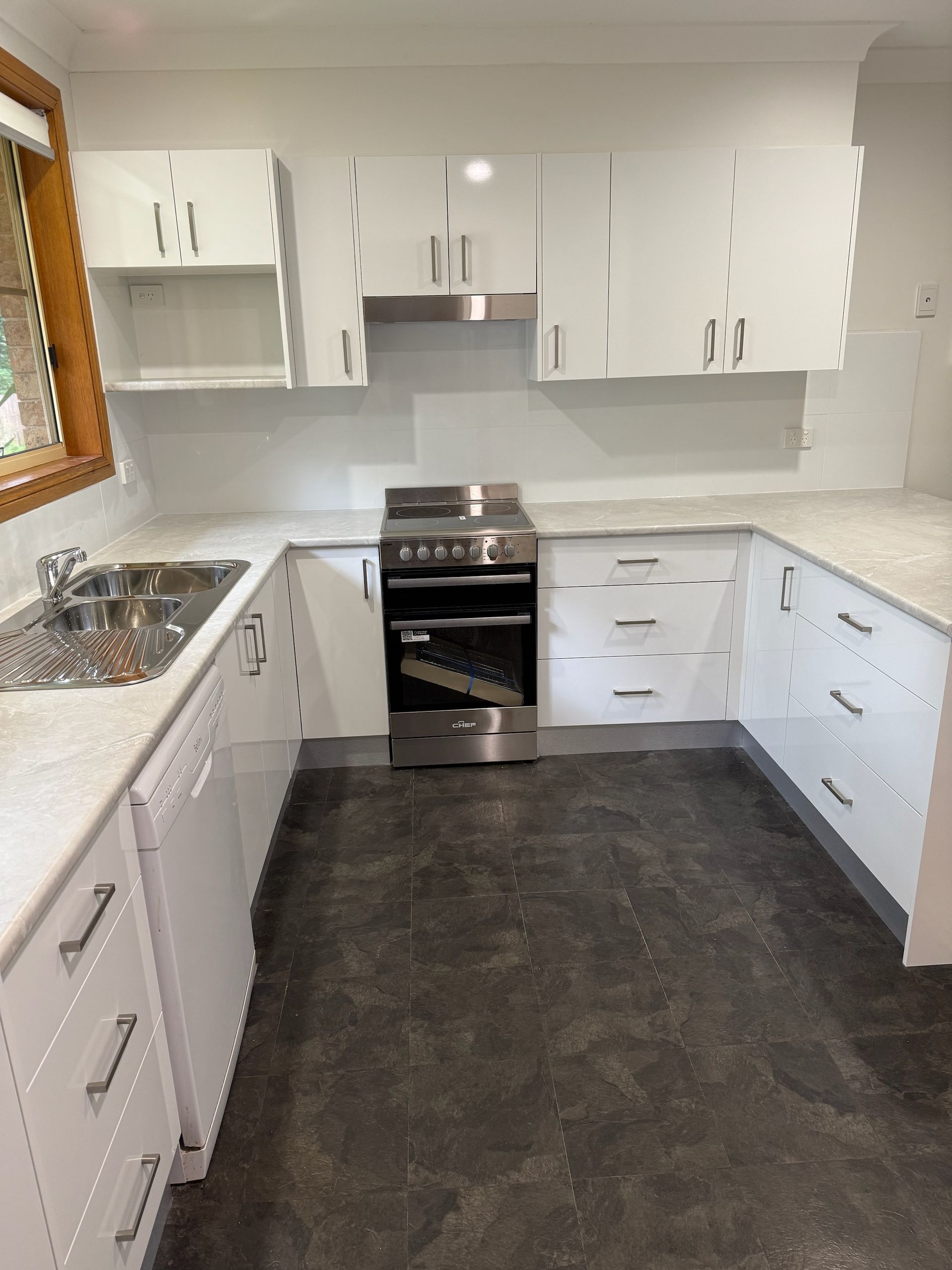 White U-shaped Kitchen With Stainless Steel Appliances and Gray Countertop — Gateway Manufacturing in Morisset, NSW