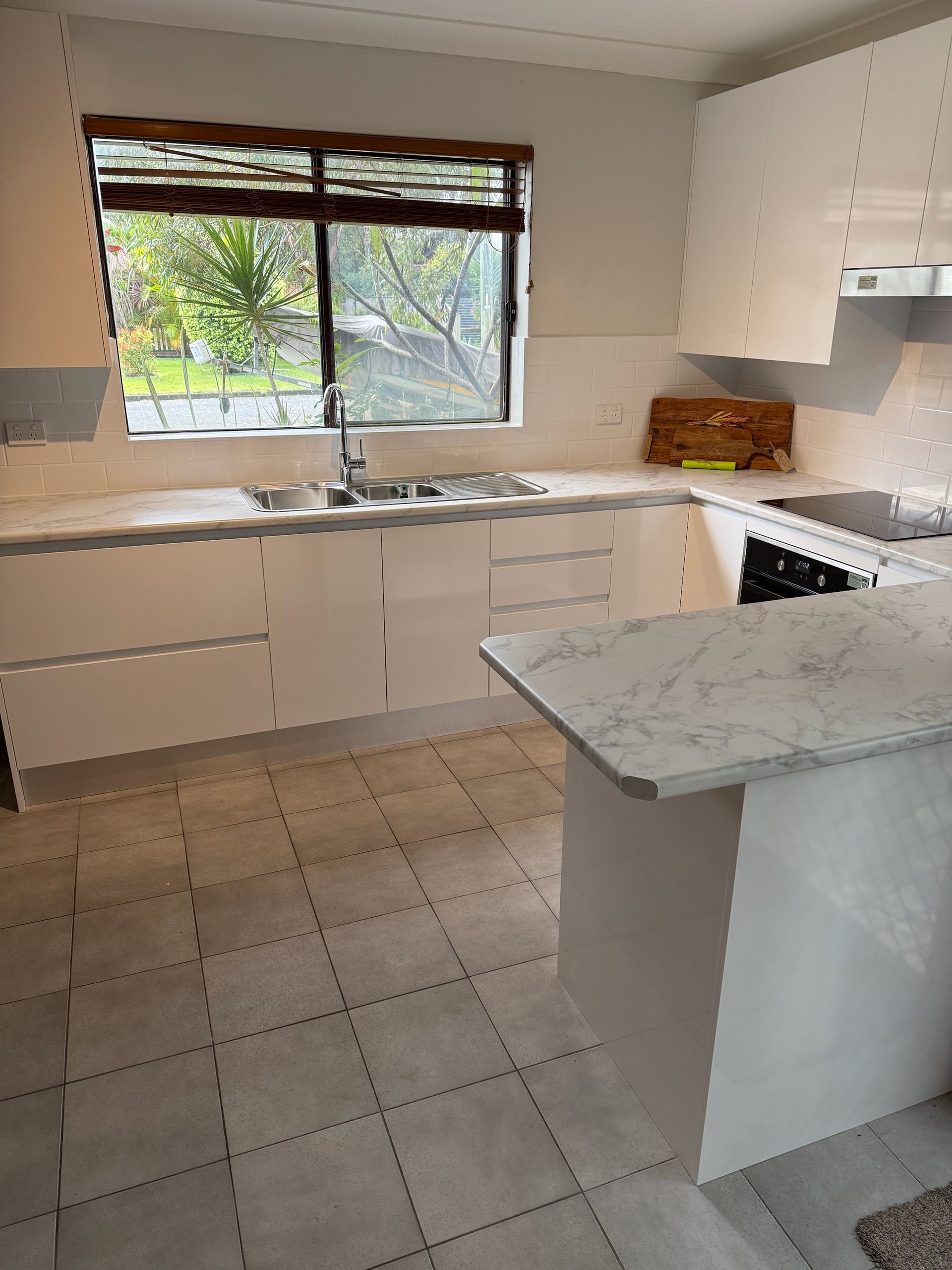 Modern White Kitchen With Stone Countertops and Large Window — Gateway Manufacturing in Port Stephens, NSW