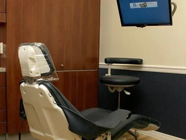 A dental office with a chair and a monitor on the wall
