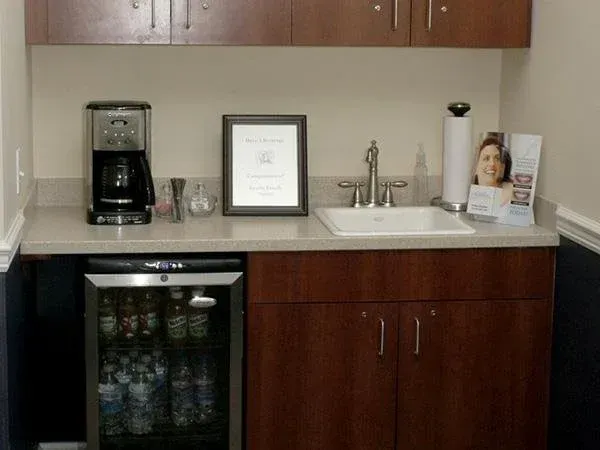 A kitchen with a sink and a coffee maker