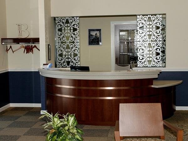 A waiting room with a wooden desk and chairs