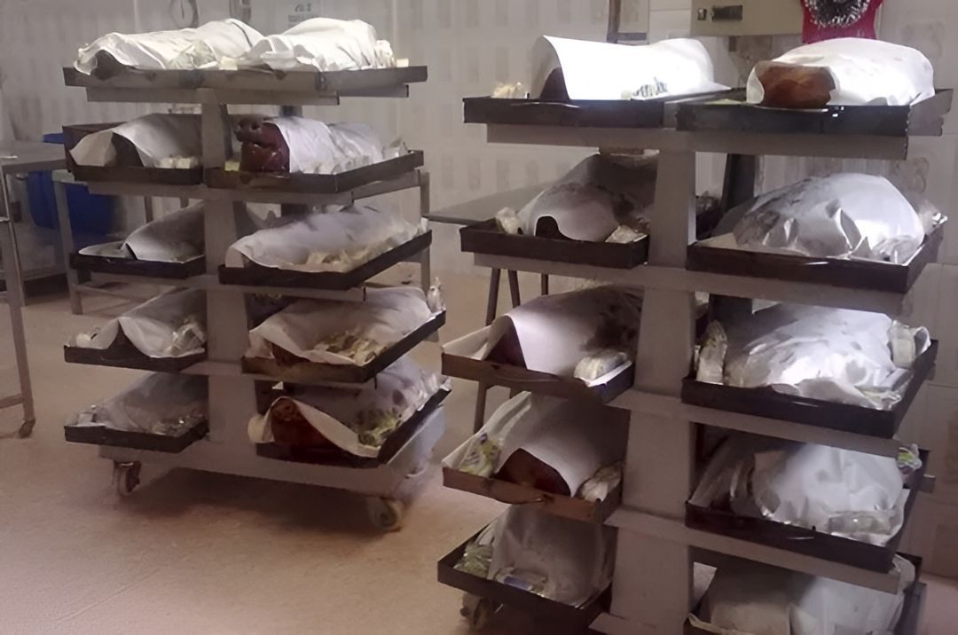 Estanterías metálicas con bandejas de ropa blanca doblada en un cuarto de almacenamiento