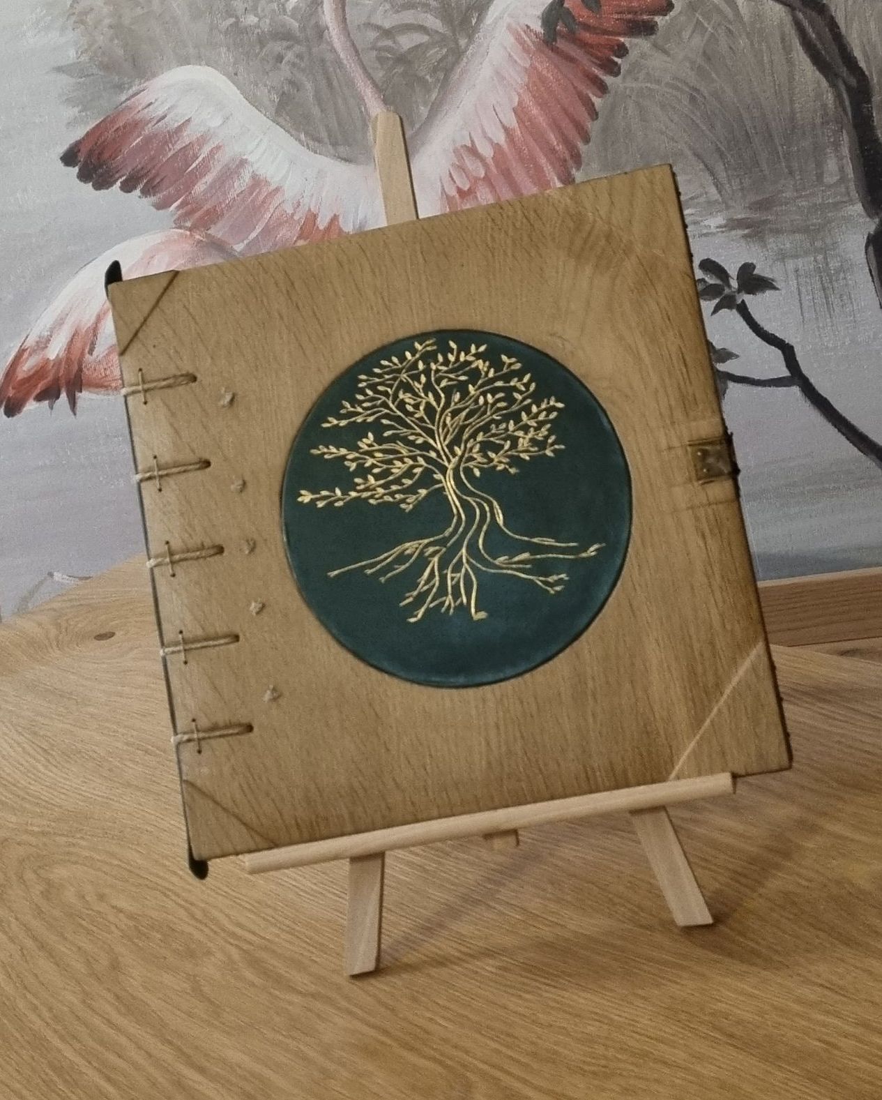 Un livre en bois avec un arbre dessus est posé sur un chevalet en bois.