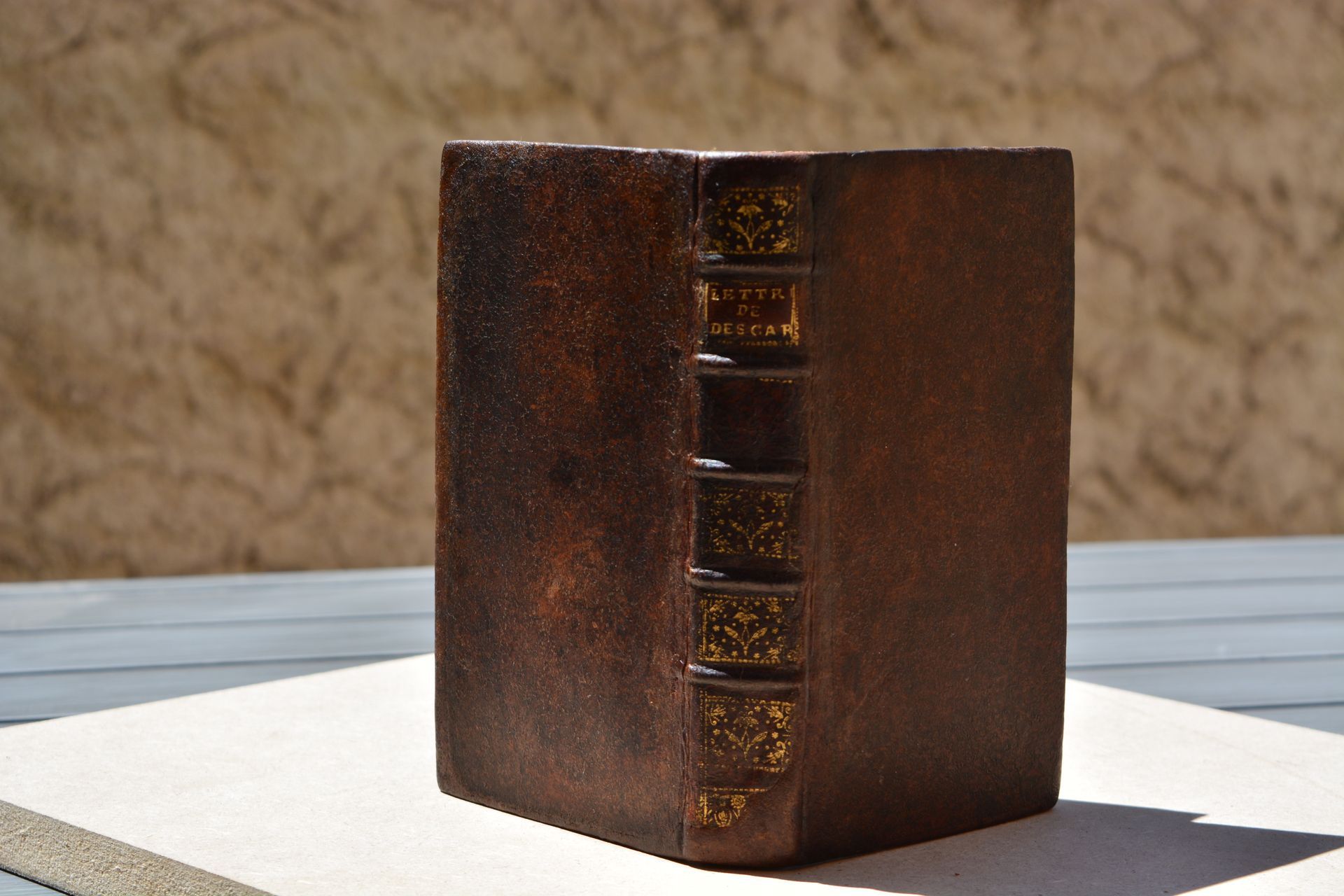 Un livre marron est posé sur une table à l'extérieur