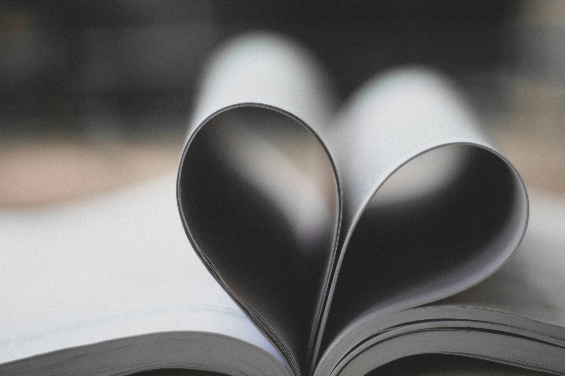 Un gros plan d'un livre ouvert avec les pages pliées en forme de cœur.