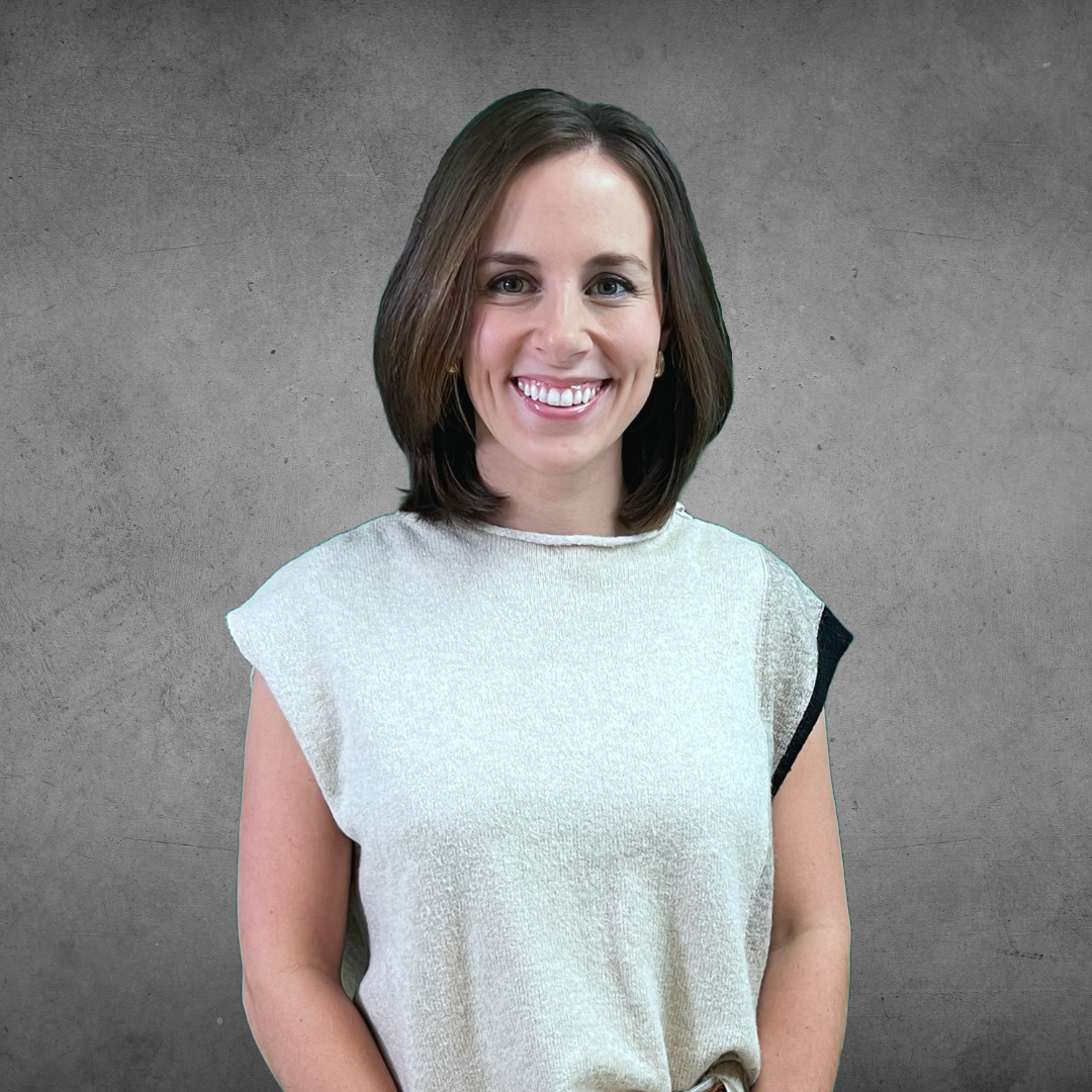 Smiling woman in a white top against a gray studio backdrop