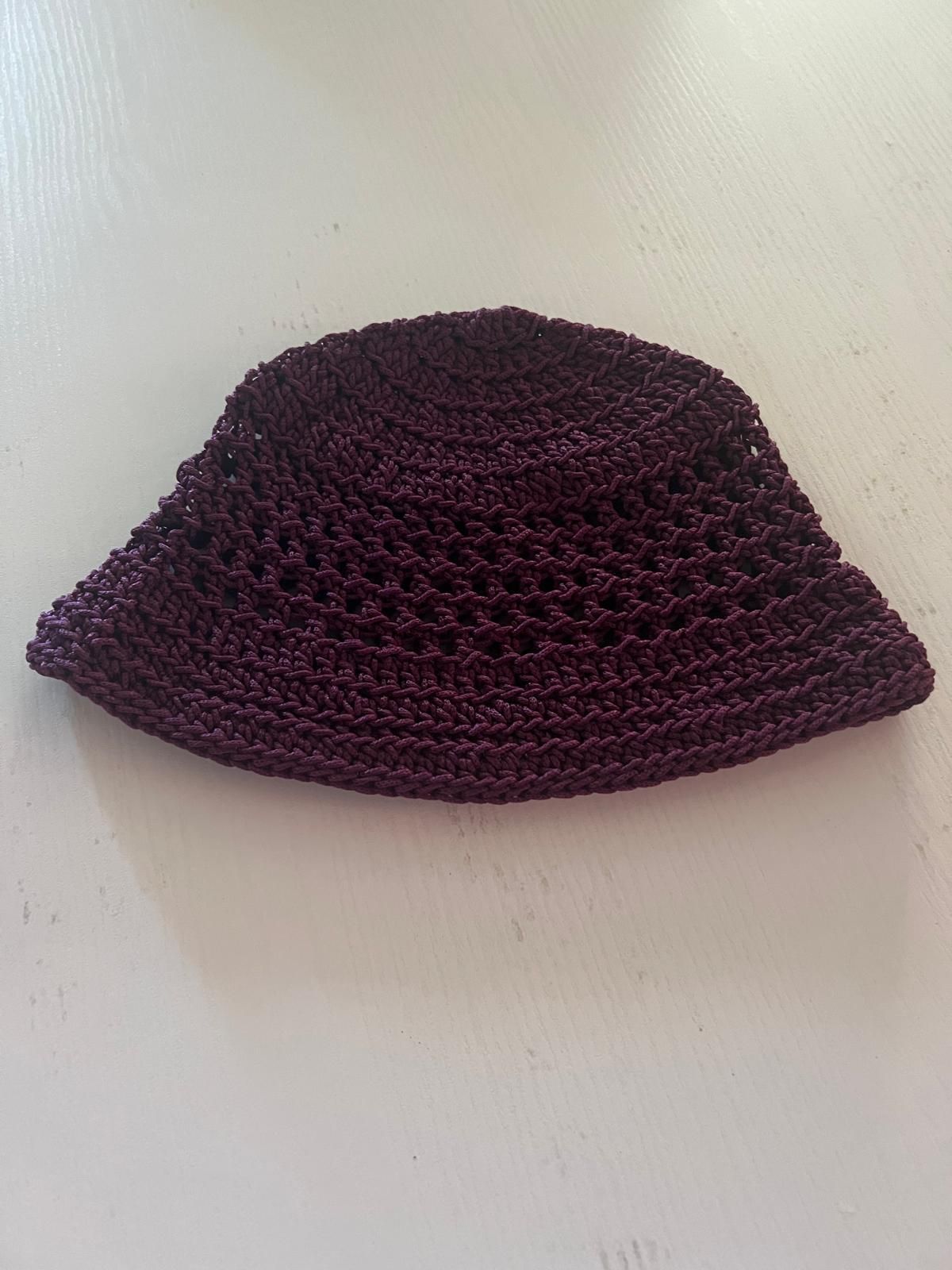 Cappello a secchiello intrecciato viola scuro su sfondo chiaro