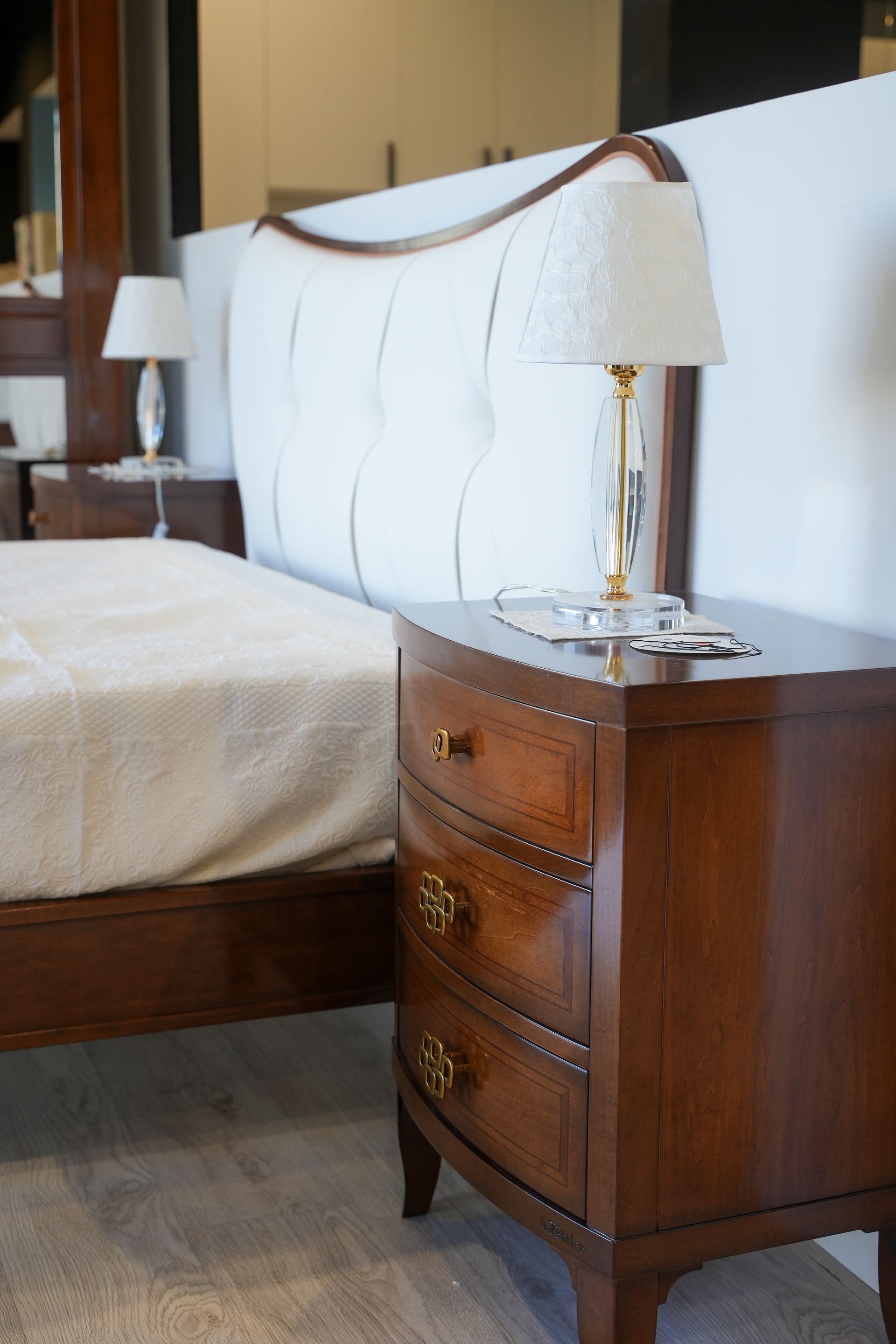 Un comodino accanto al letto con una lampada sopra