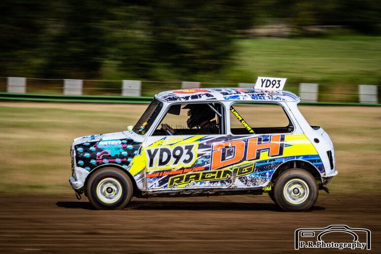 A racing car is driving down a dirt road.