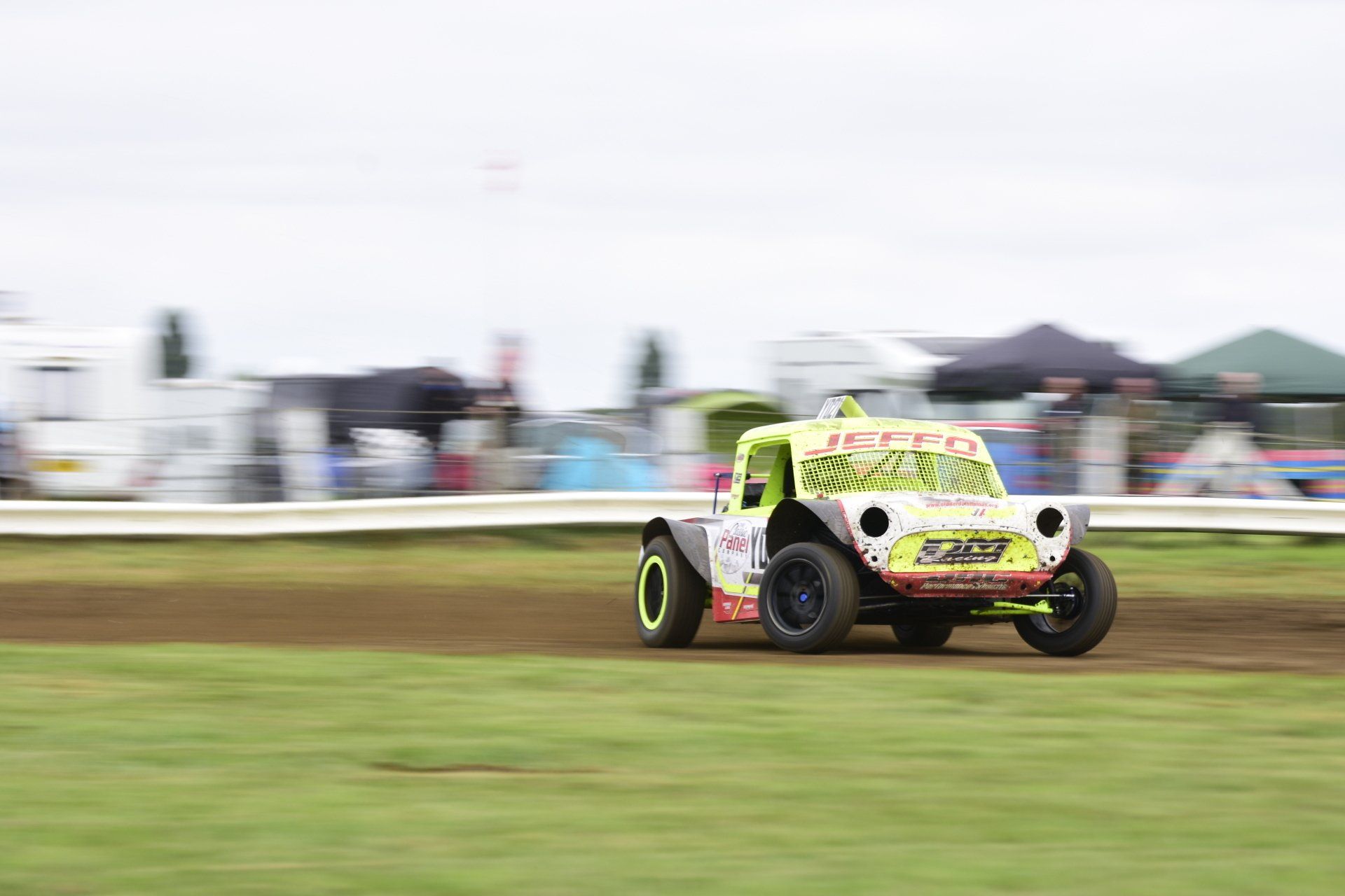 A race car is driving down a dirt track.