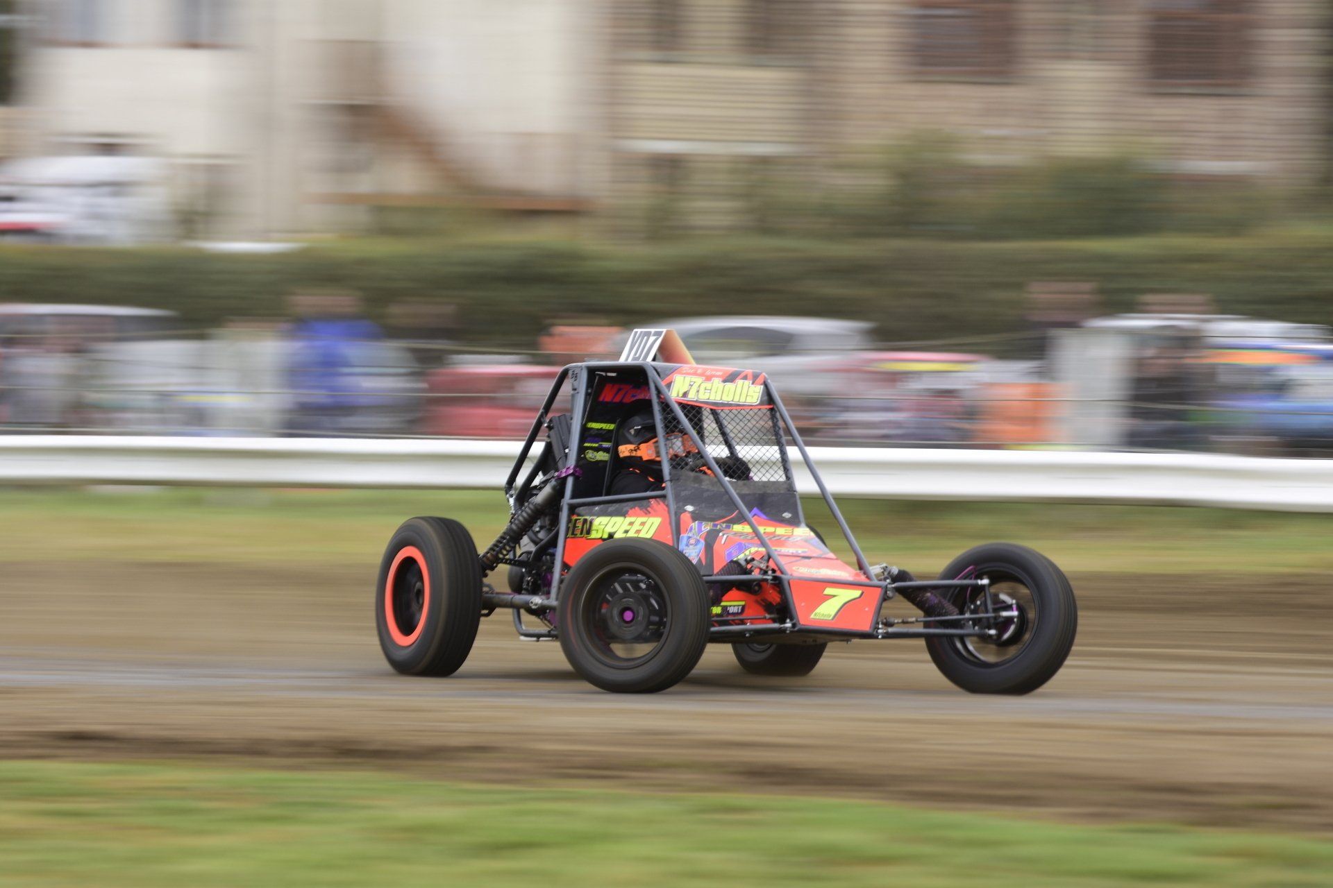 A person is driving a buggy on a dirt track.