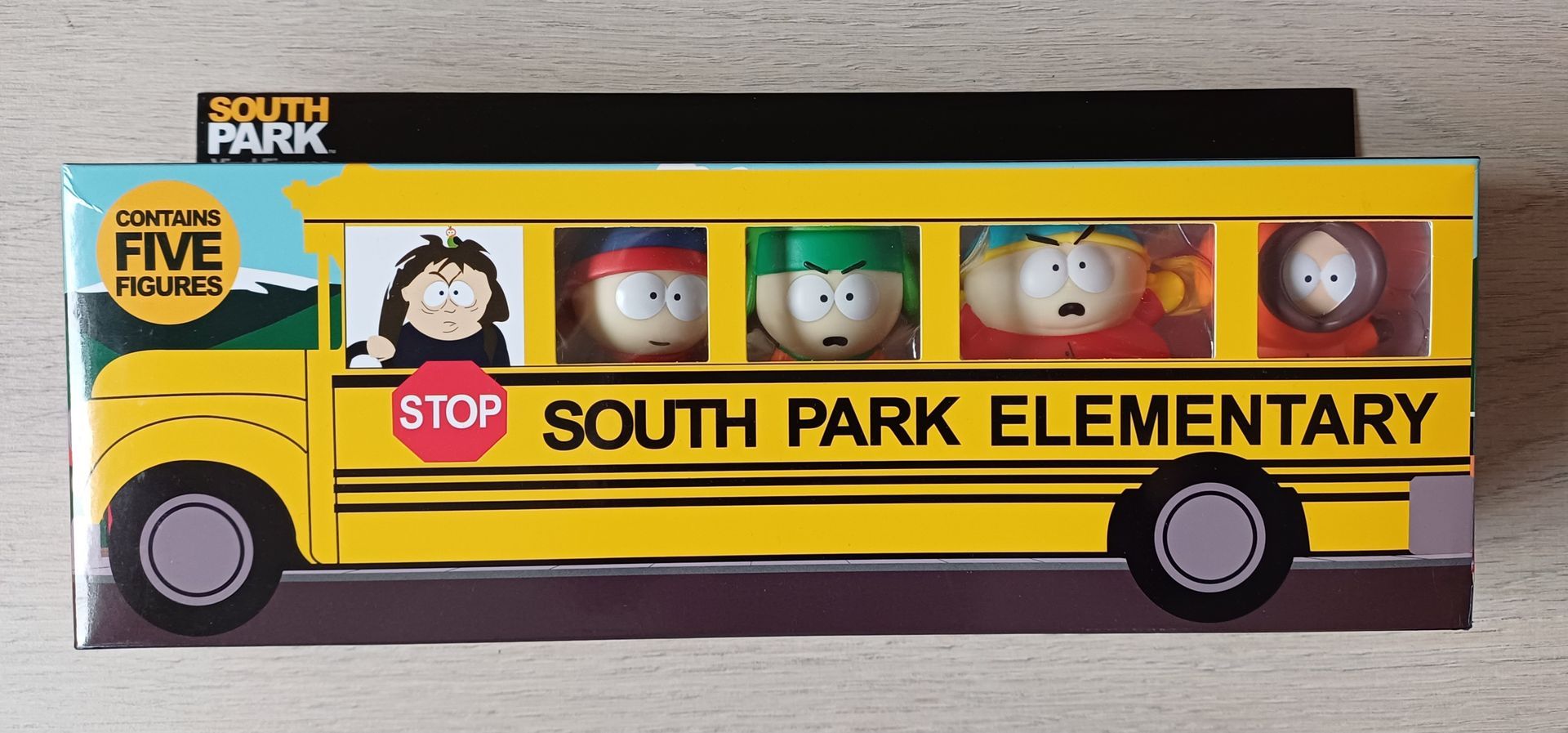 South Park speelgoedset in een gele schoolbusdoos met vijf zichtbare personagefiguren.
