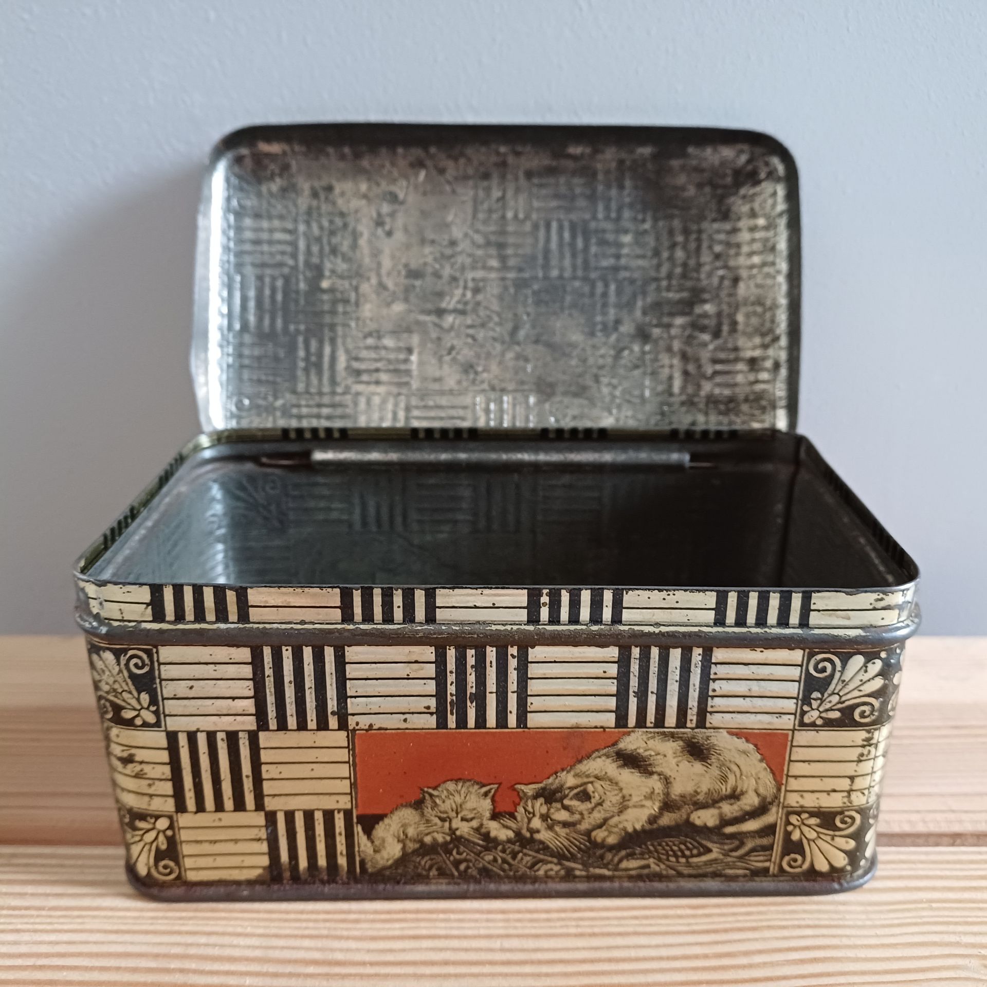 Bovenkant vintage blikje met katten afbeeldingen.