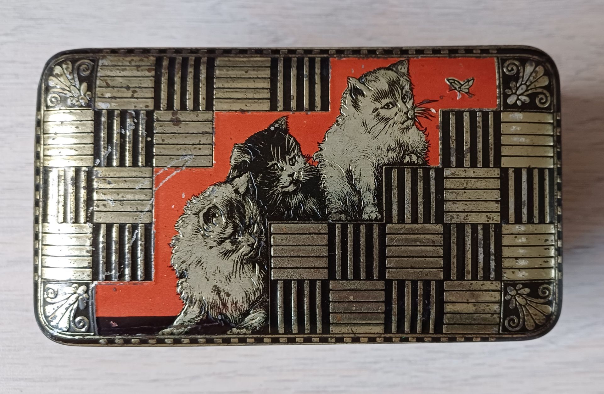 Bovenkant vintage blikje met katten afbeeldingen.