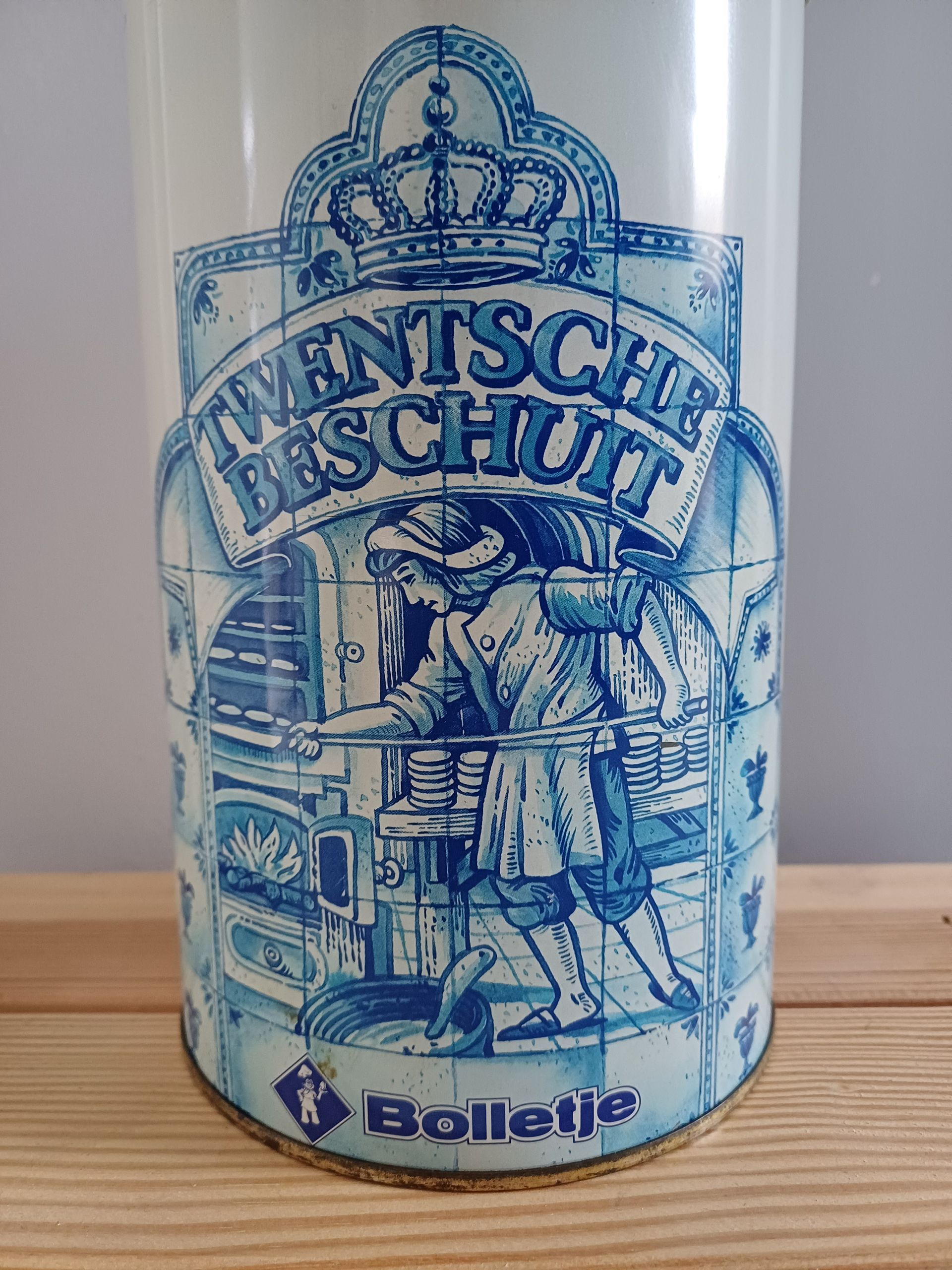 Blauw-witte cilindrische koekjesblik met een bakkersmotief en de tekst 
