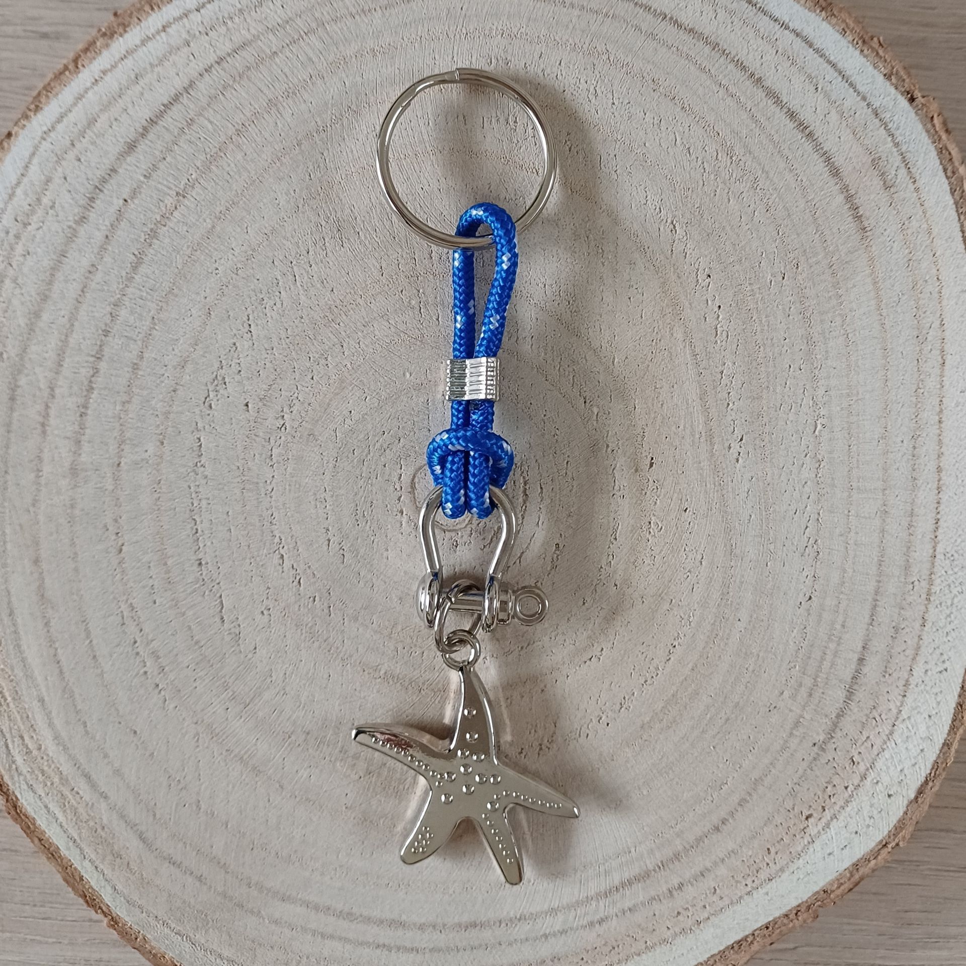 Sleutelhanger met zeesterhangertje en een blauw koord.