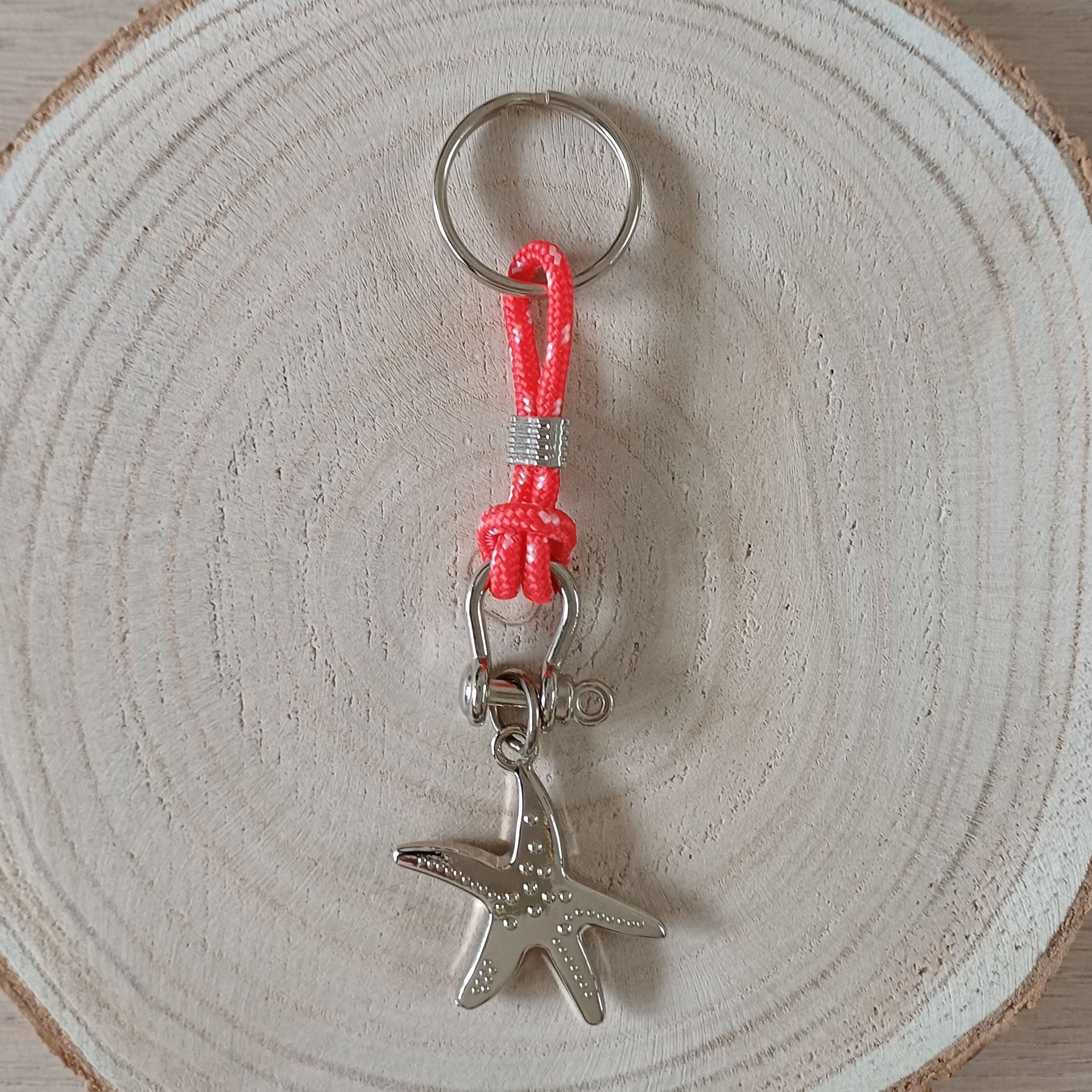 Sleutelhanger met zeesterhangertje en een rood koord.