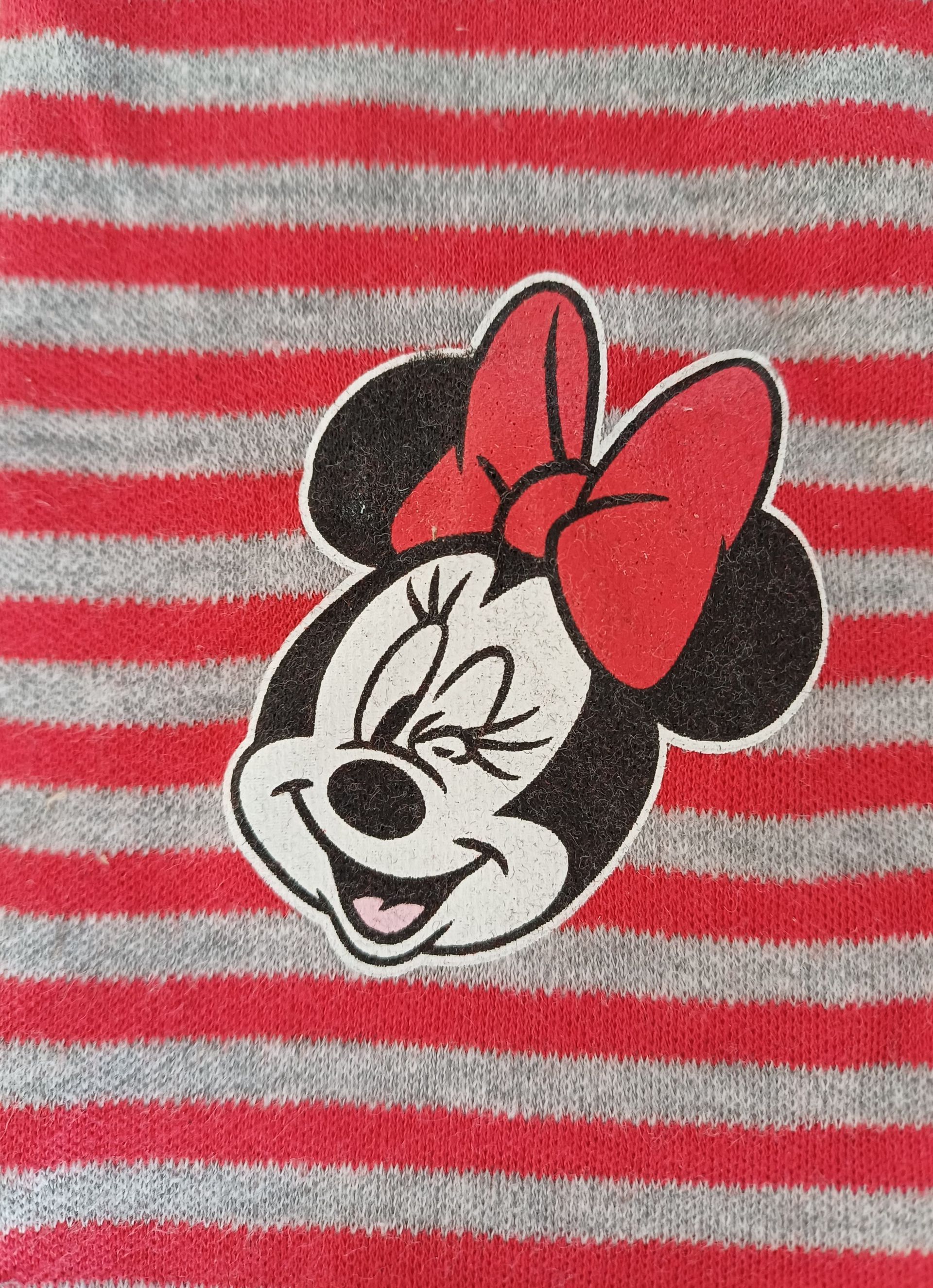 Rood-wit gestreepte babybroek met grijze tailleband en boorden. Met Minnie Mouse-gezichtjes op beide broekspijpen.
