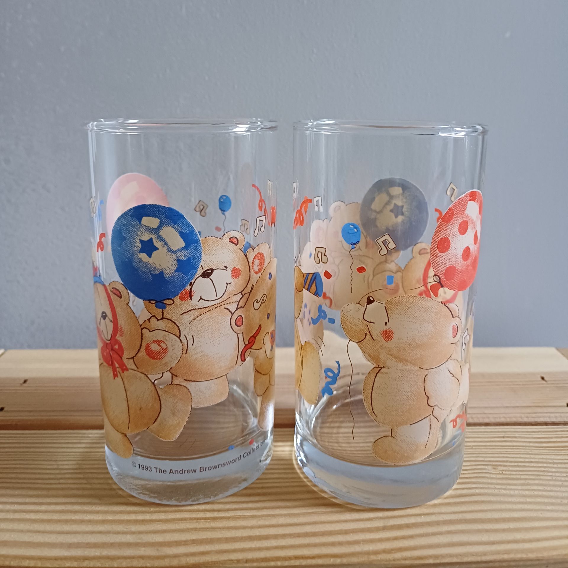 Twee vintage longdrinkglazen van Forever Friends met afbeeldingen van feestvierende beren, ballonnen en muzieknoten.