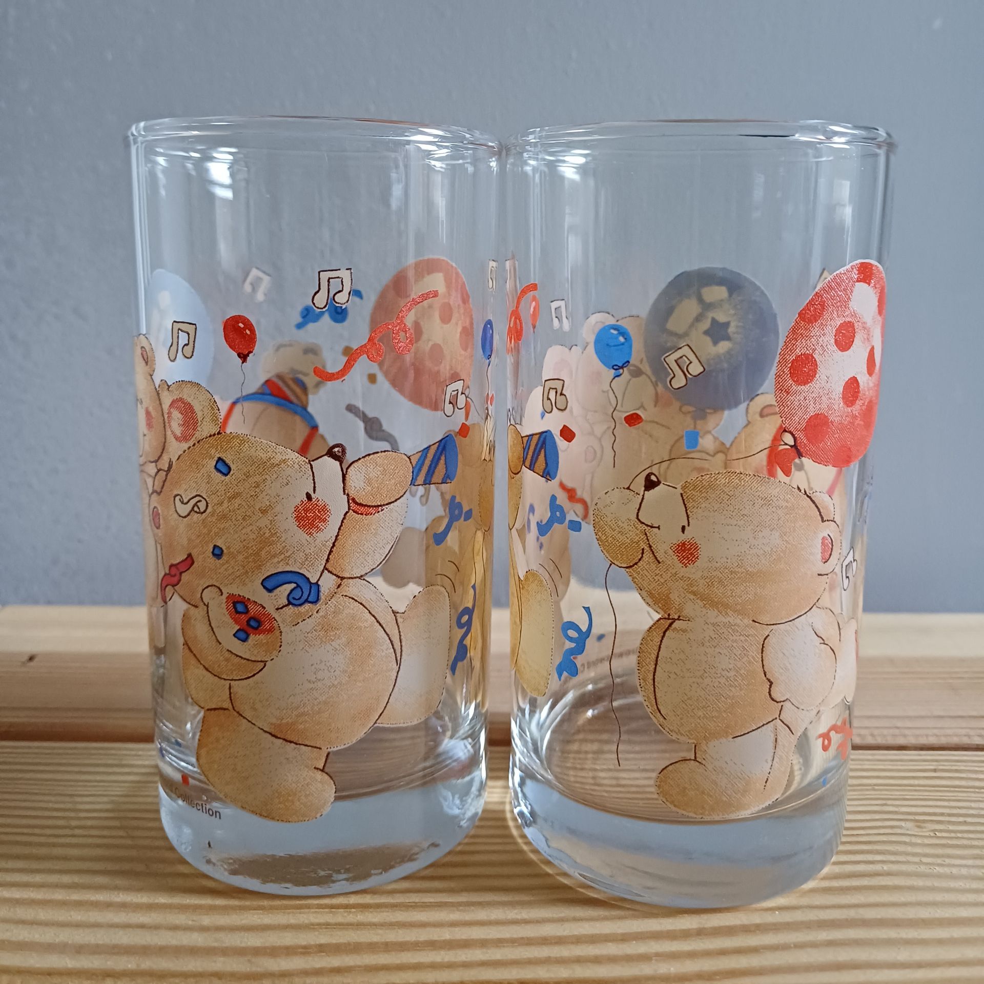 Twee vintage longdrinkglazen van Forever Friends met afbeeldingen van feestvierende beren, ballonnen en muzieknoten.