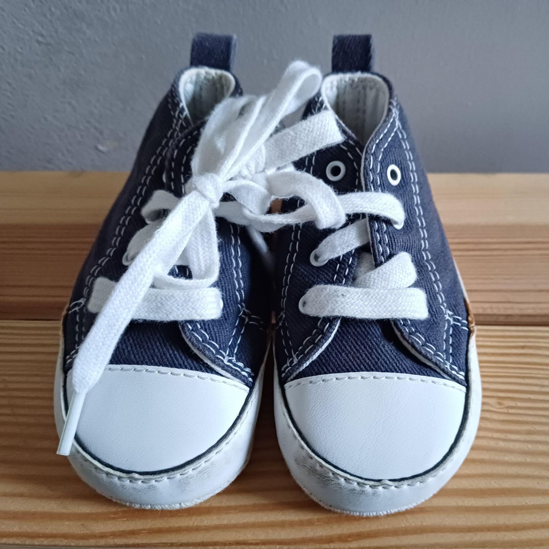 Donkerblauwe babysneakers met witte zolen en veters.