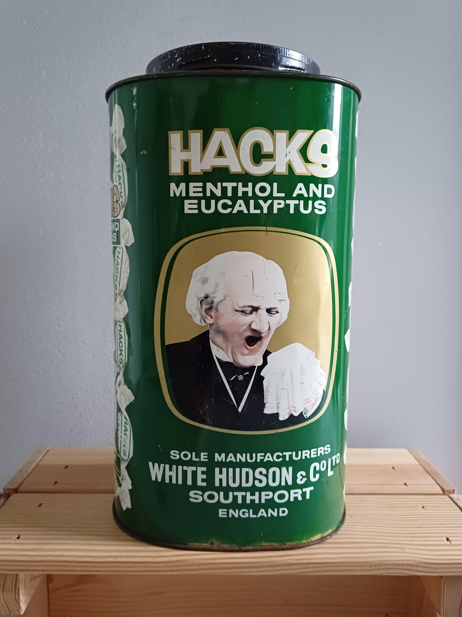 Vintage Hacks hoestbonbons blik. Groen blik met een afbeelding van een man die zijn hand voor zijn mond houdt.
