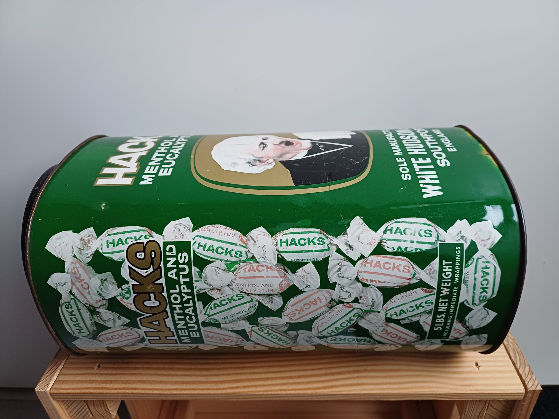 Vintage Hacks hoestbonbons blik. Groen blik met een afbeelding van een man die zijn hand voor zijn mond houdt.