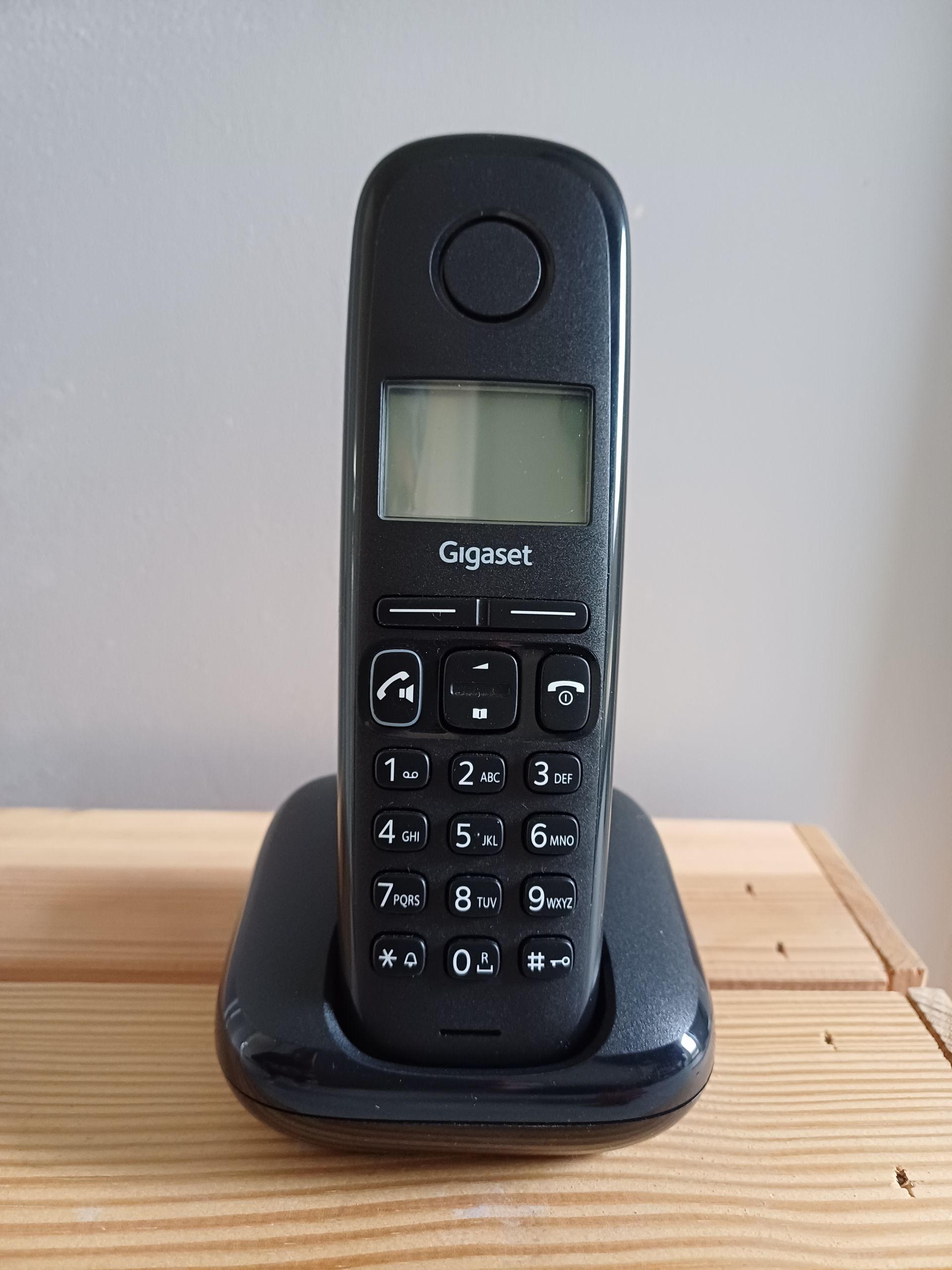 Gigaset AS190 draadloze telefoon in doos, zwarte handset op basisstation en twee oplaadkabels.