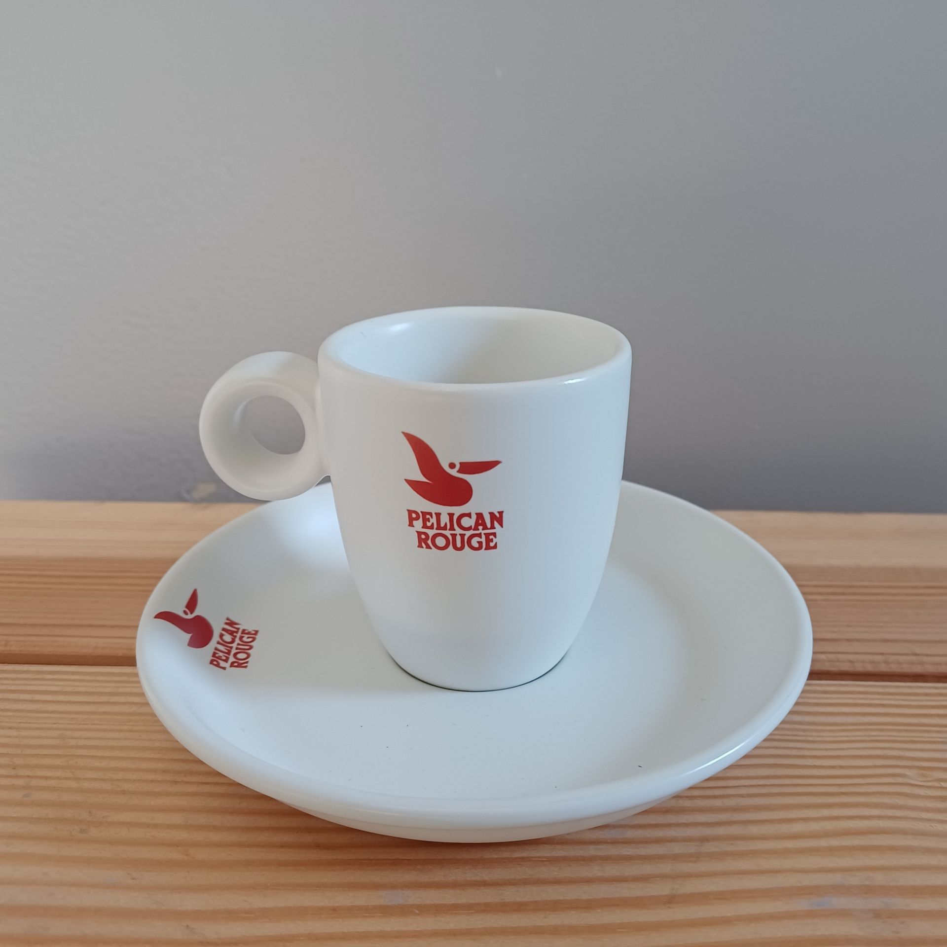 Witte koffiekop en schotel met rood 