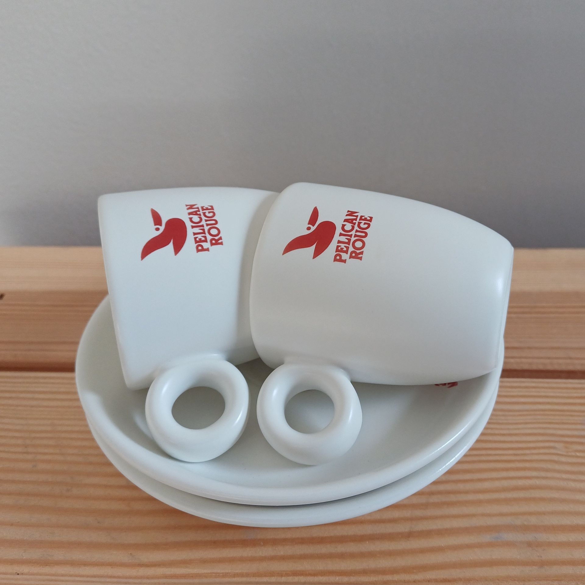 Witte koffiekop en schotel met rood 