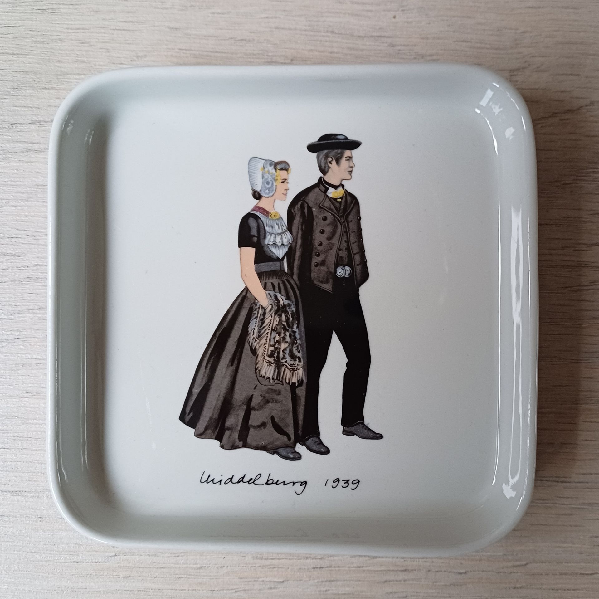 Twee witte rechthoekige dienbladen met afbeeldingen van traditionele volksdansers.