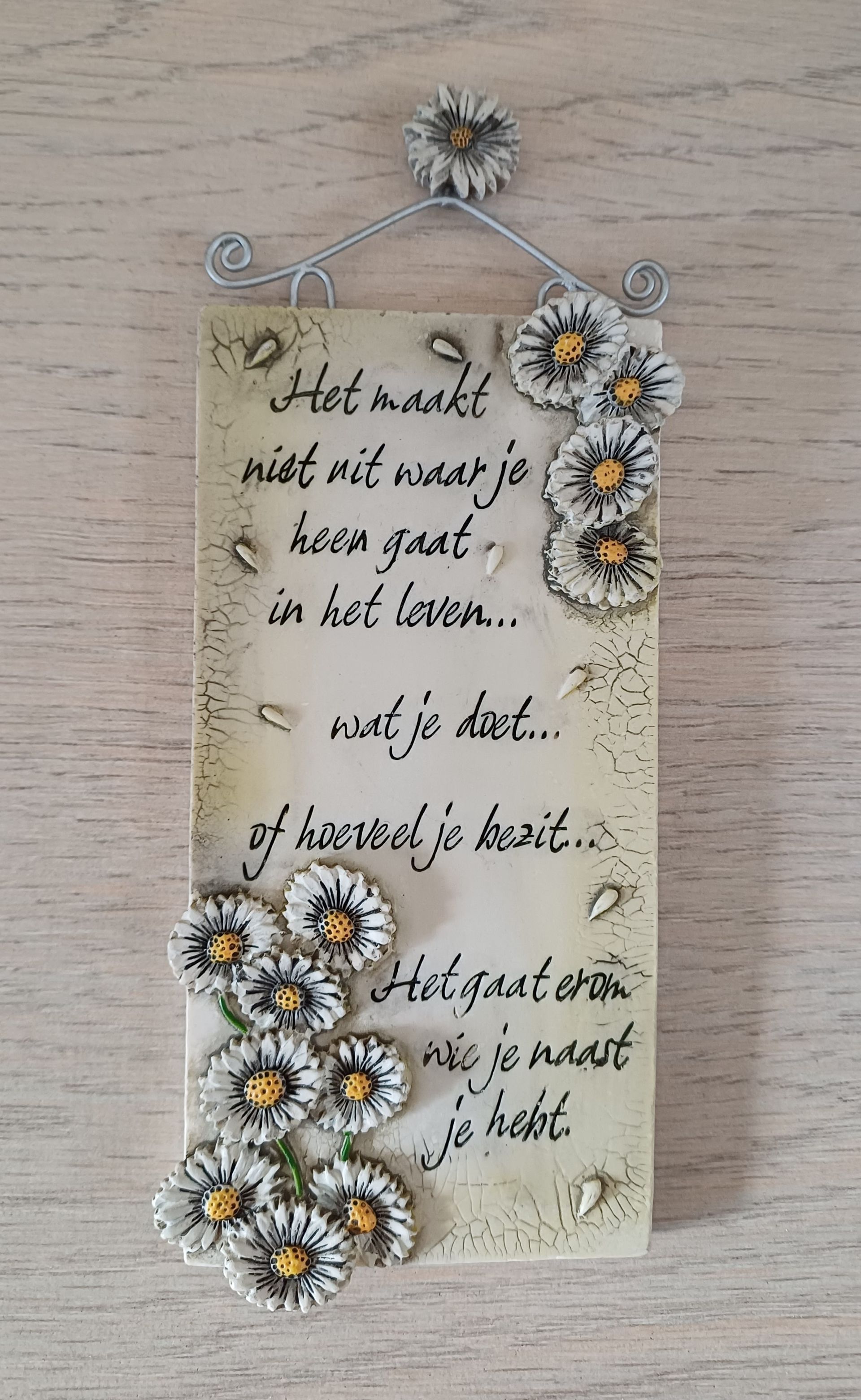 Twee decoratieve plaquettes met tekst en bloemversieringen.