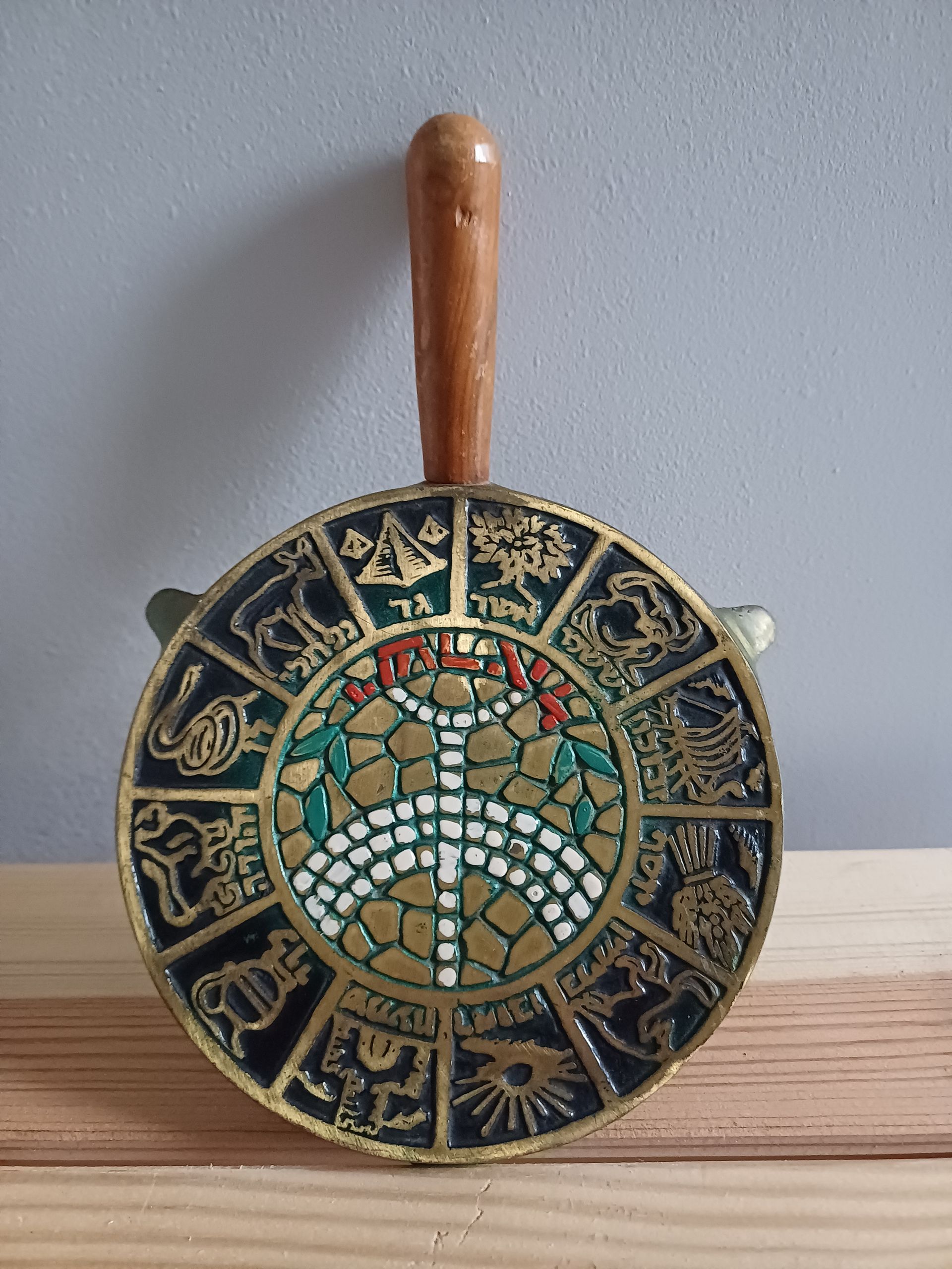 Messing asbak met een houten handvat, sterrenbeelden langs de rand en een centraal ontwerp van een boom.