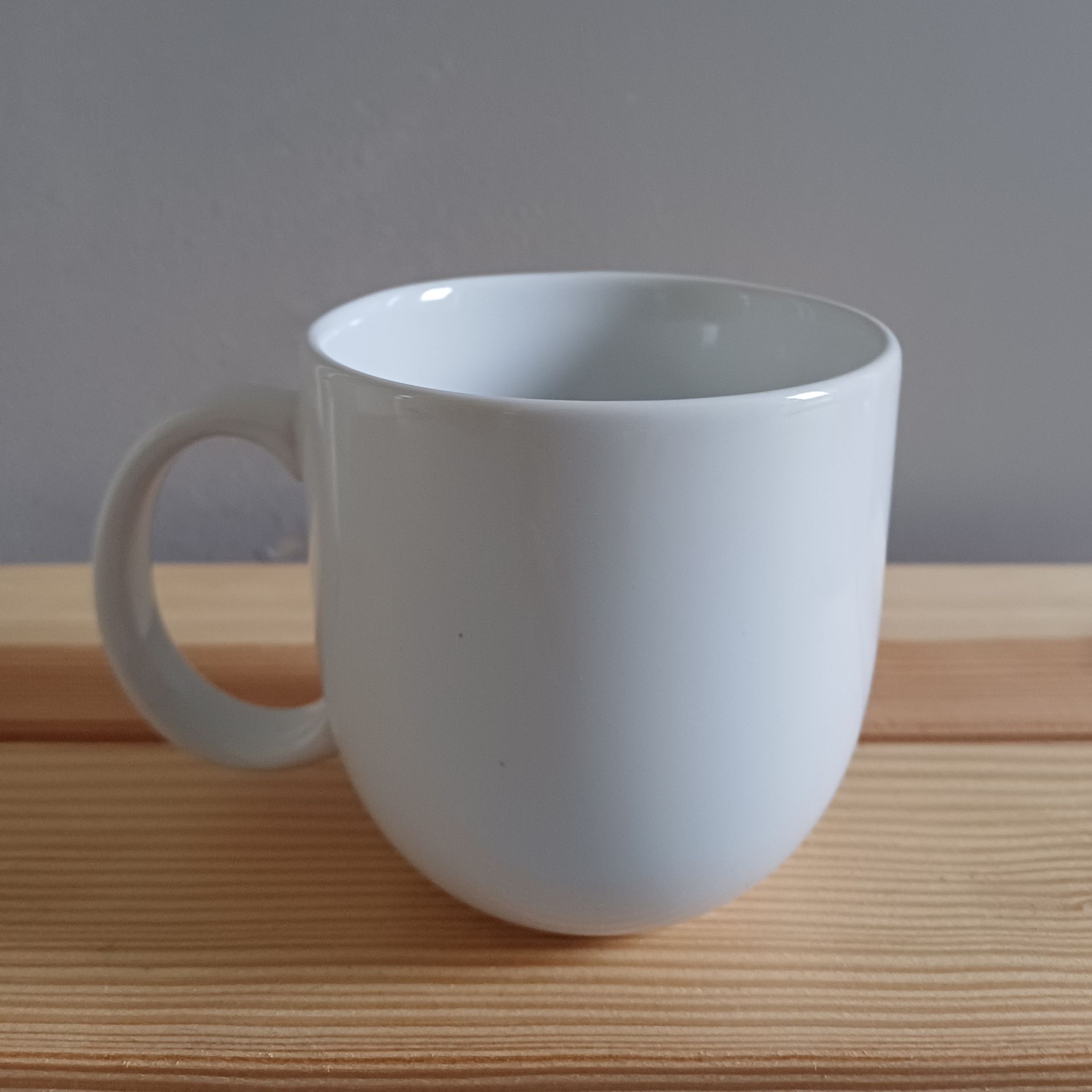 Witte mok met zwart decoratief ontwerp en het woord 