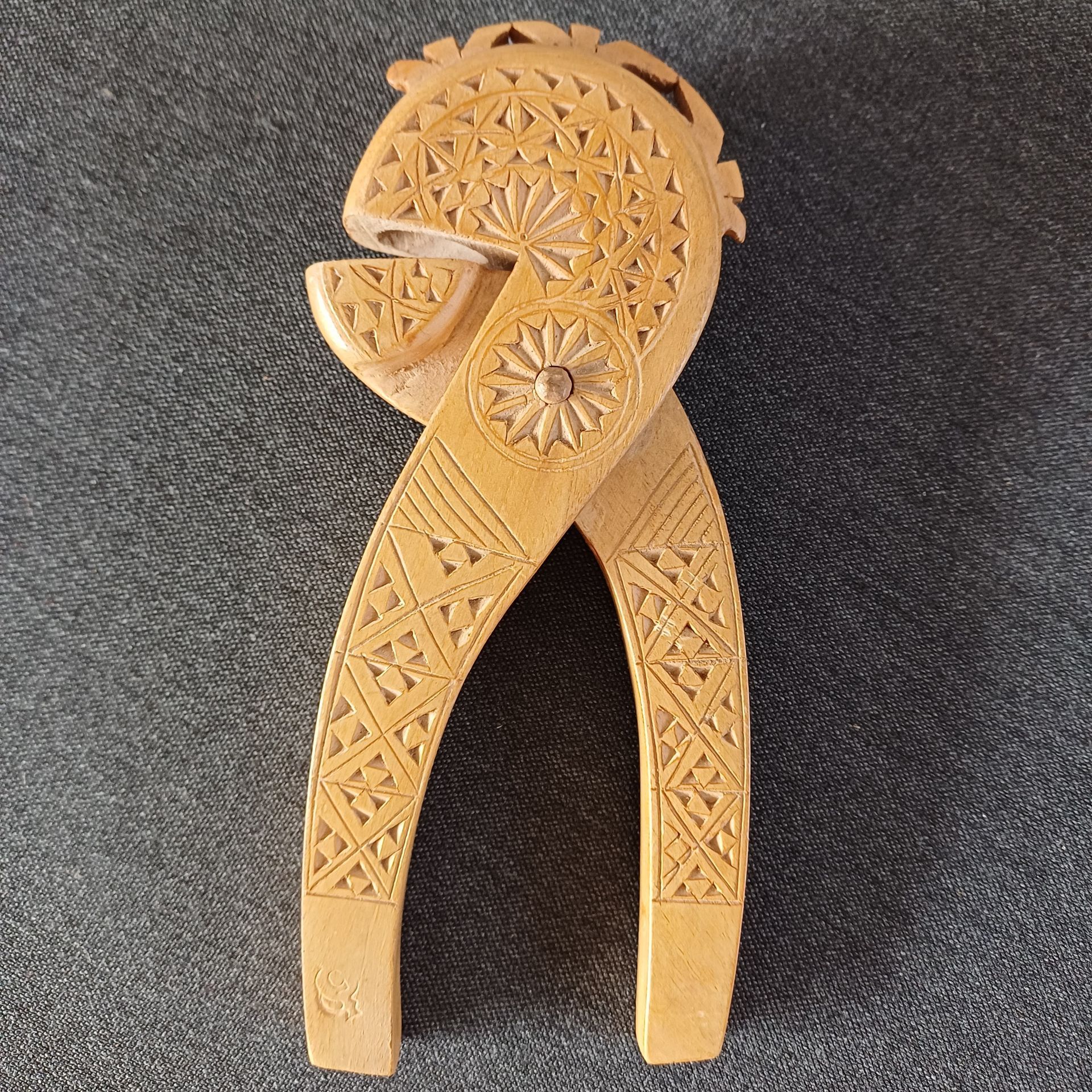 Een uit hout gesneden notenkraker met ingewikkelde geometrische en florale patronen.
