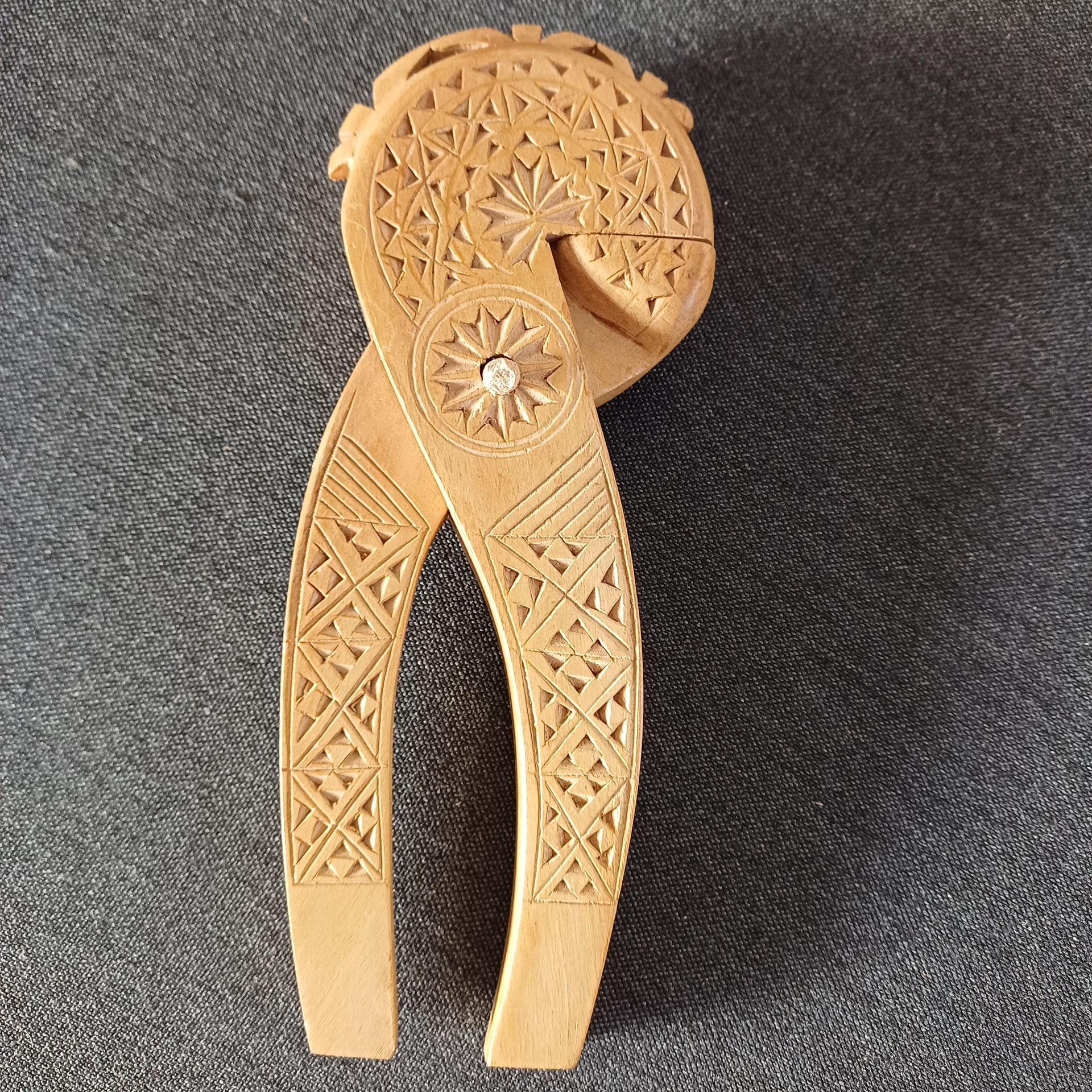 Een uit hout gesneden notenkraker met ingewikkelde geometrische en florale patronen.