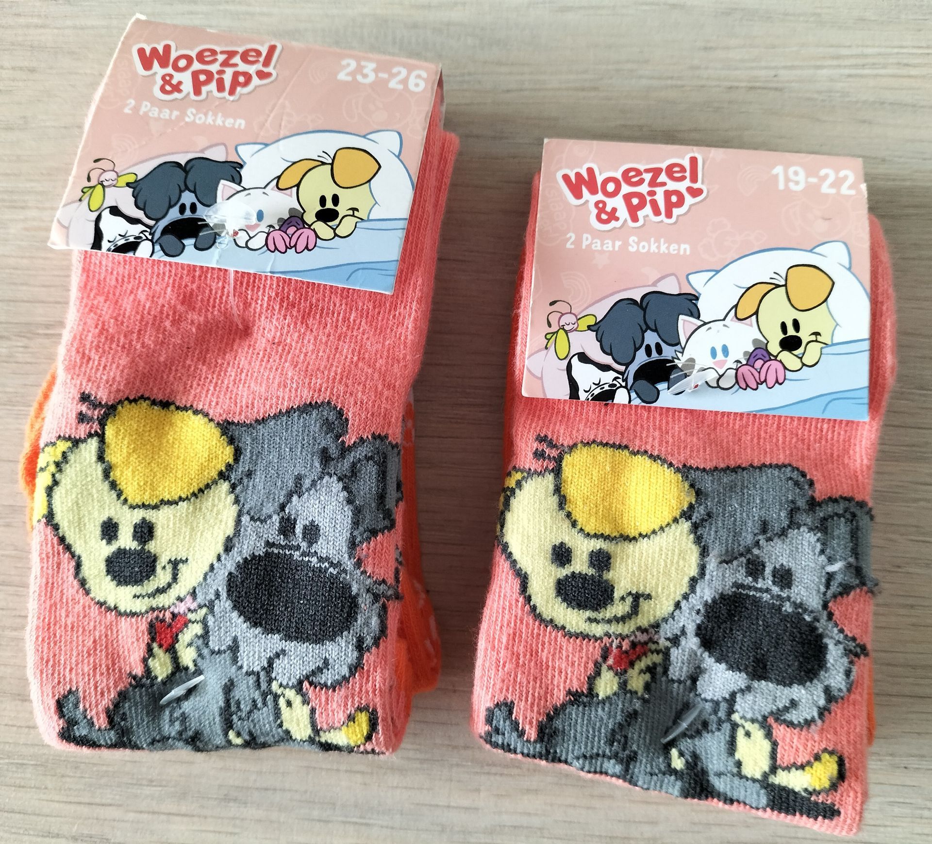 Twee paar roze Woezel & Pip sokken met cartoonhondjes. Maten 23-26 en 18-22.