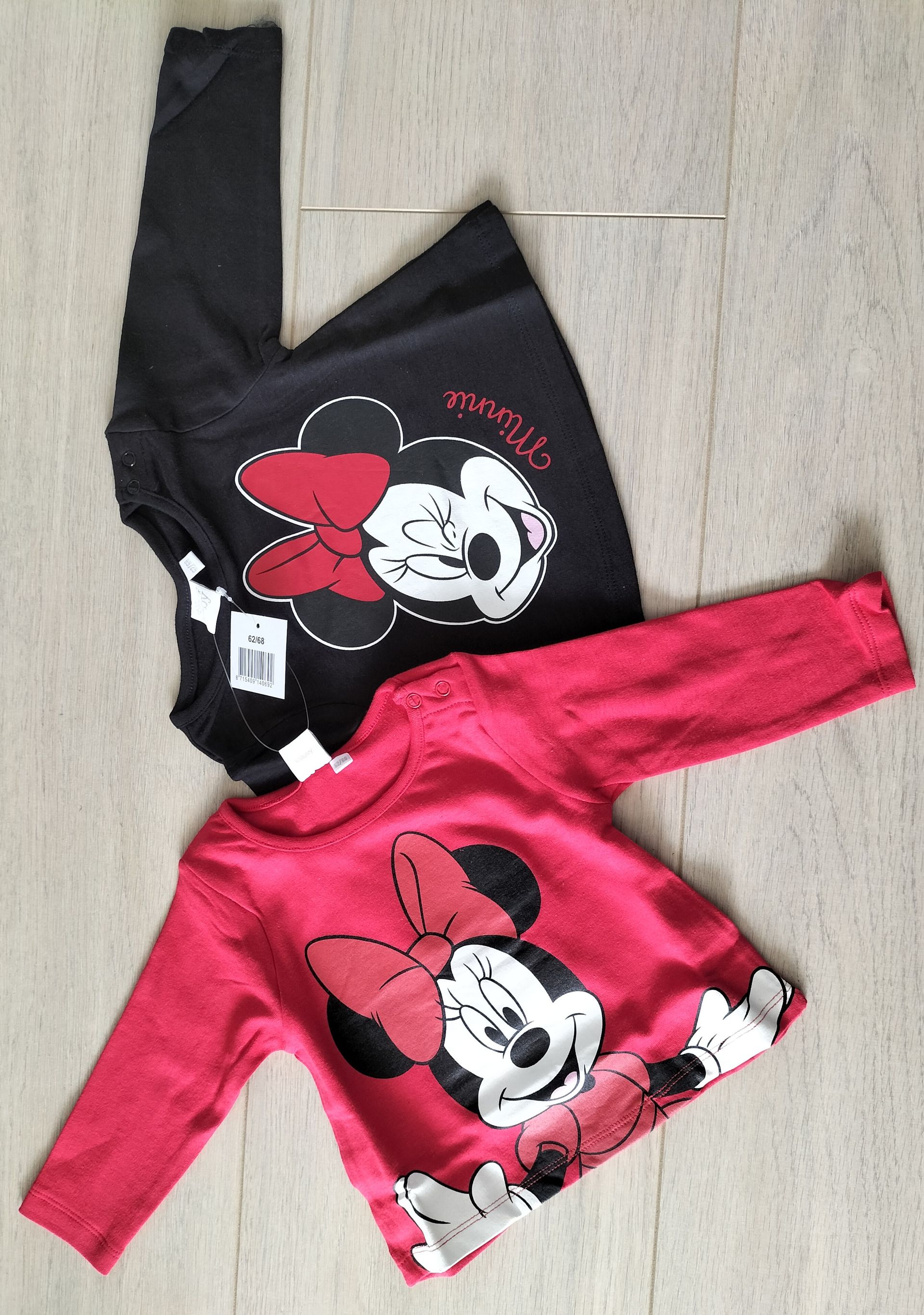 Twee shirts met lange mouwen van Minnie Mouse: een rode en een zwarte, met Minnie's gezicht en strik op de voorkant.